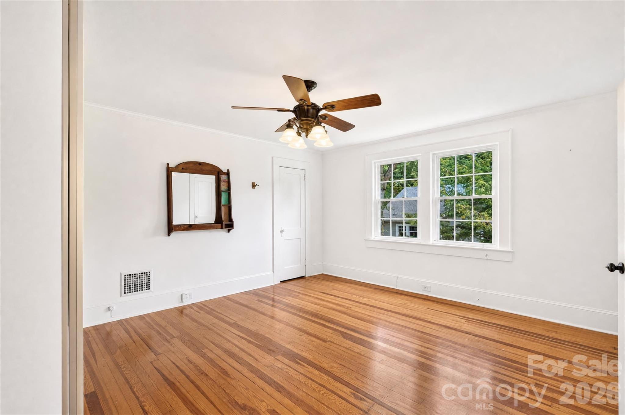 The primary bedroom is filled with natural light from a pair of large windows, hardwood floors and plenty of room for furnishings. - 638 Carolina Avenue, Gastonia