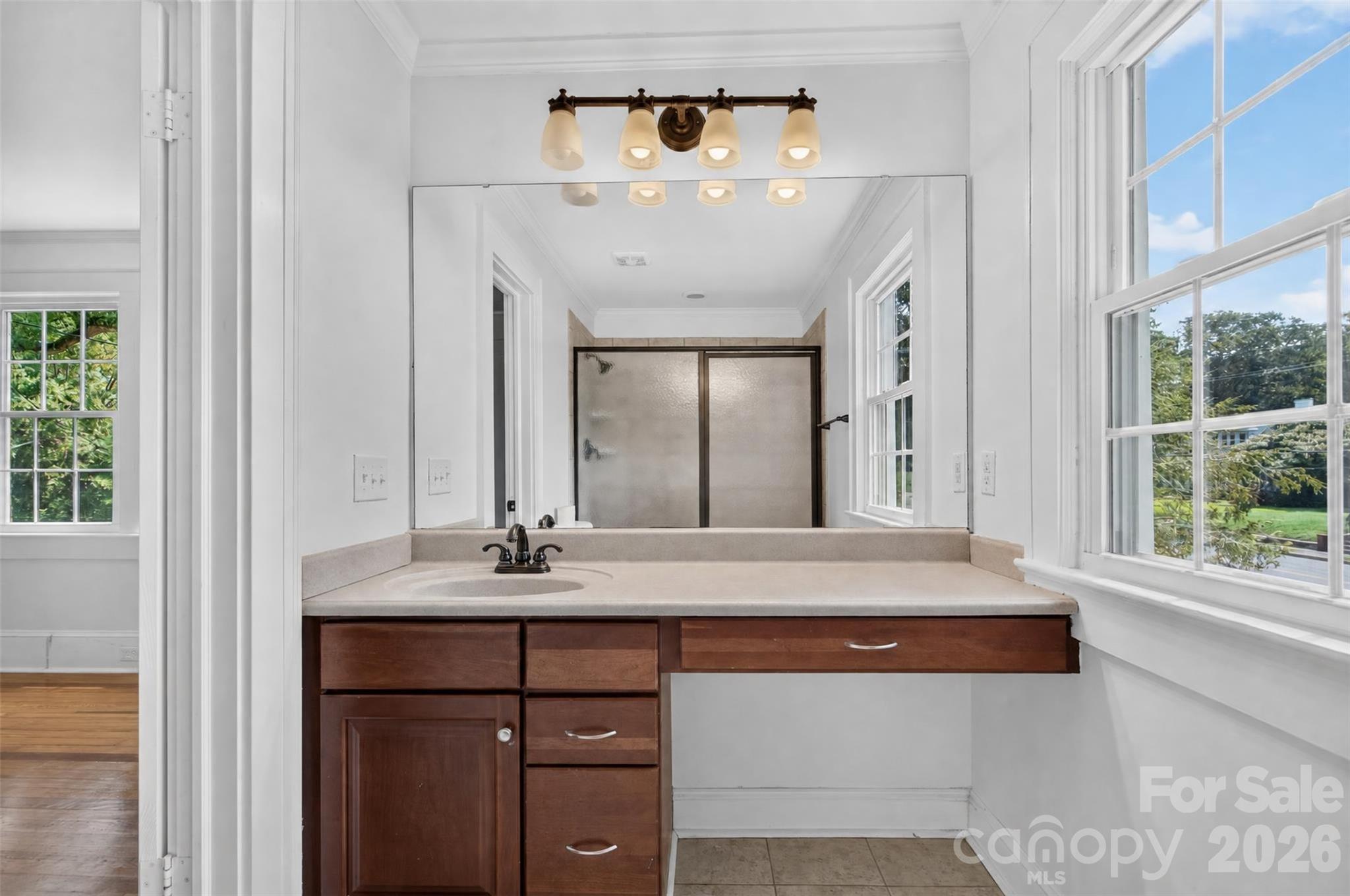 Primary bath includes an extended vanity oversized mirror and a large window that brings in plenty of natural light. - 638 Carolina Avenue, Gastonia