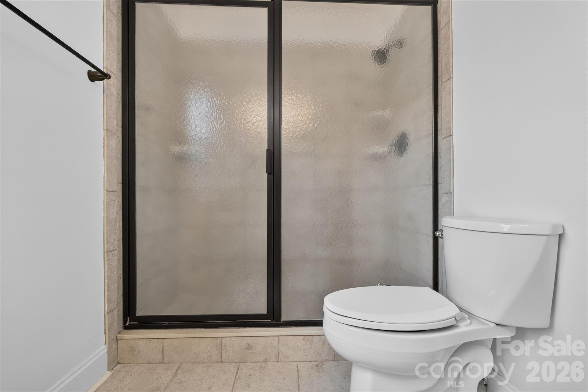 Another view of the primary bath shows the full-size tiled shower with sliding glass enclosure. - 638 Carolina Avenue, Gastonia