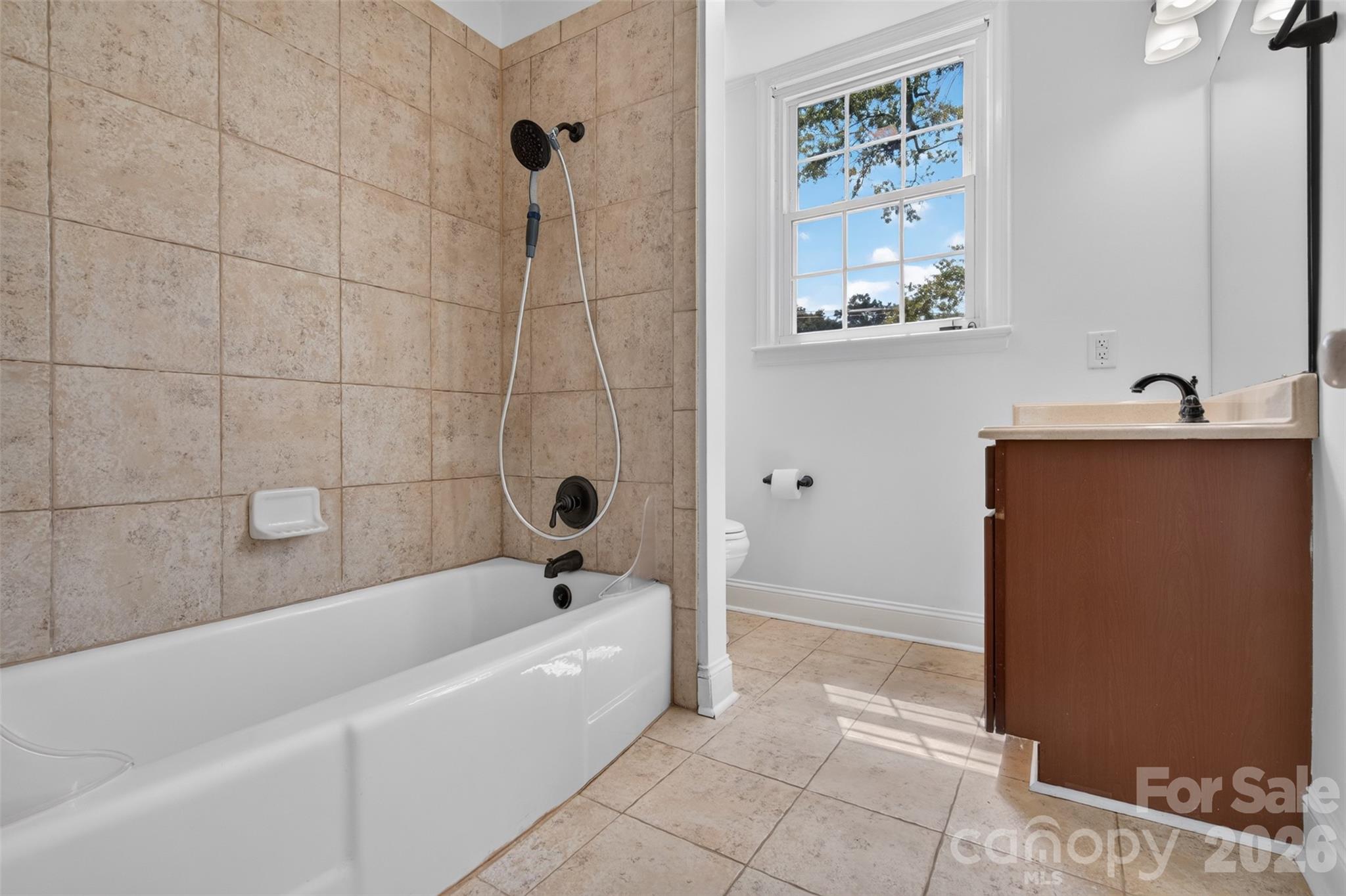 Upstairs hall bath with a single vanity tub with child surround and a window for natural light. - 638 Carolina Avenue, Gastonia