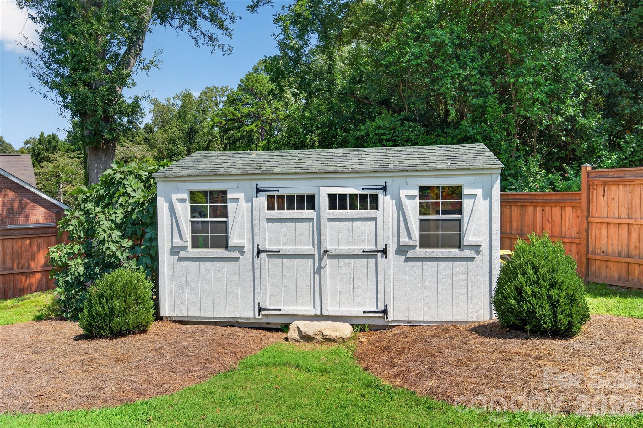 A dedicated storage shed provides plenty of space for outdoor essentials, with a covered potting area tucked behind for gardening projects and supplies. - 638 Carolina Avenue, Gastonia