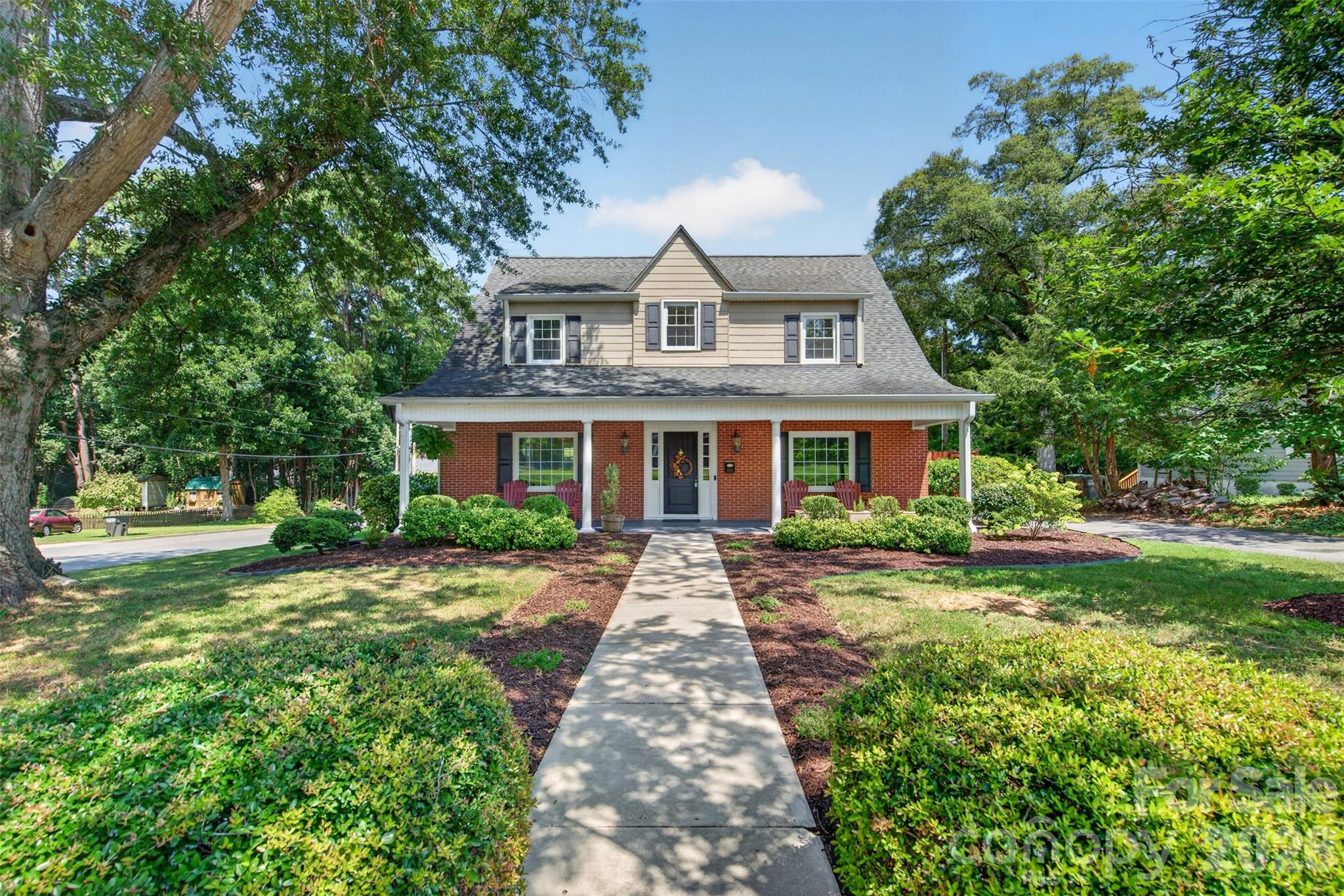 Classic curb appeal framed by mature trees and established landscaping with a broad covered front porch create a warm and welcoming approach. - 638 Carolina Avenue, Gastonia