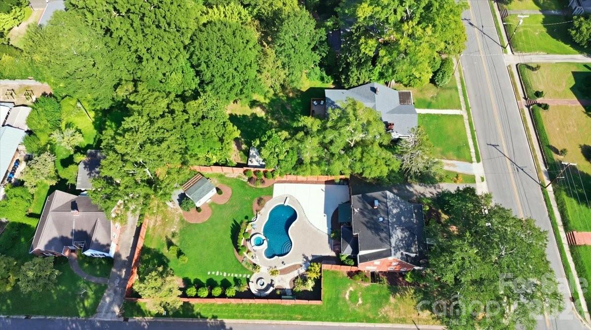 The overall perspective showcases the home, expansive fenced backyard, and thoughtfully designed out-store living spaces. - 638 Carolina Avenue, Gastonia