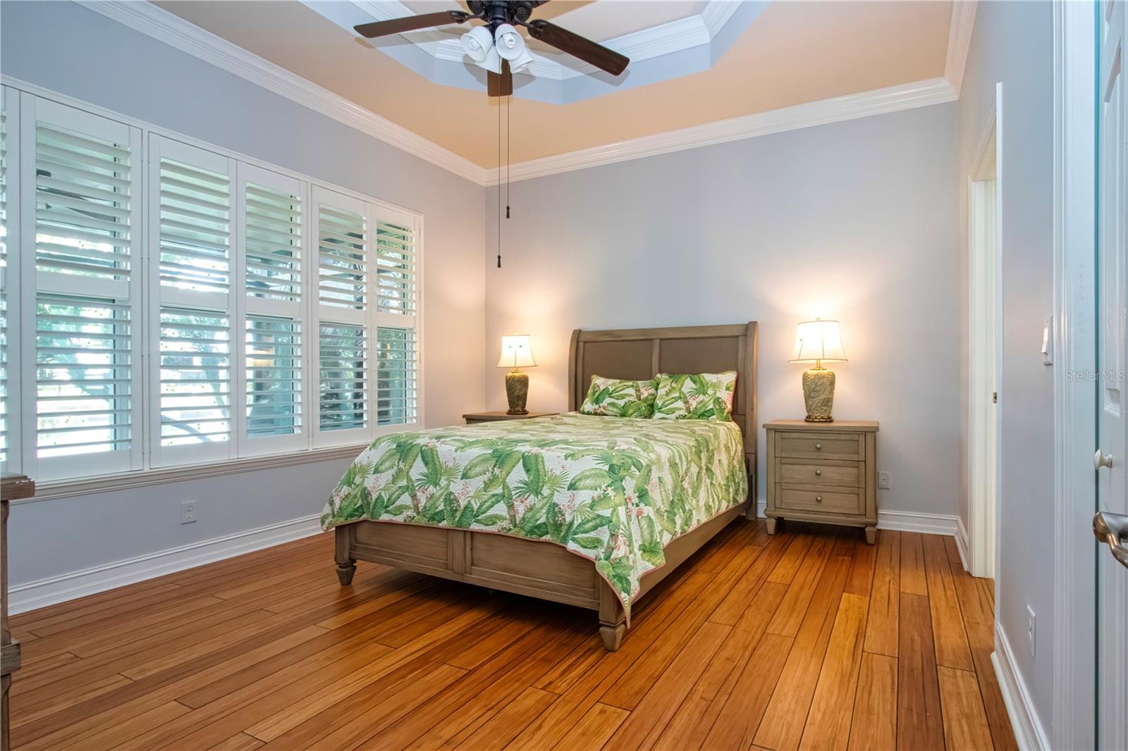 Primary Bedroom-coffered ceiling, plantation shutters,wood flooring - 15847 COBBLE MILL DR, WIMAUMA
