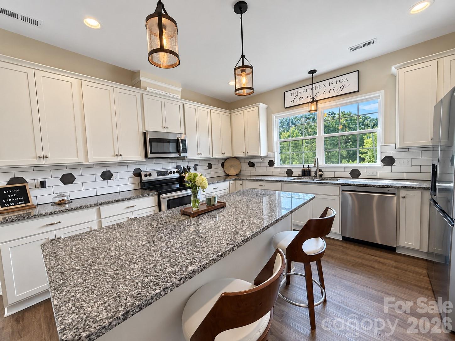 Beautiful kitchen with white cabinets, granite counters, and stainless steel appliances - 9201 Providence Road S, Waxhaw