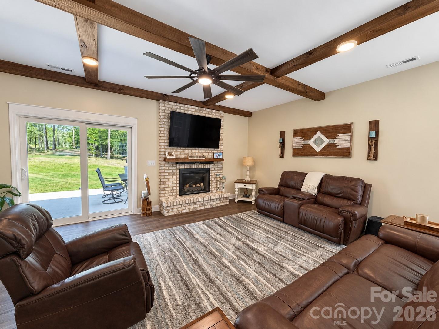 Living room with new wood beams, lighting, and stone fireplace - 9201 Providence Road S, Waxhaw