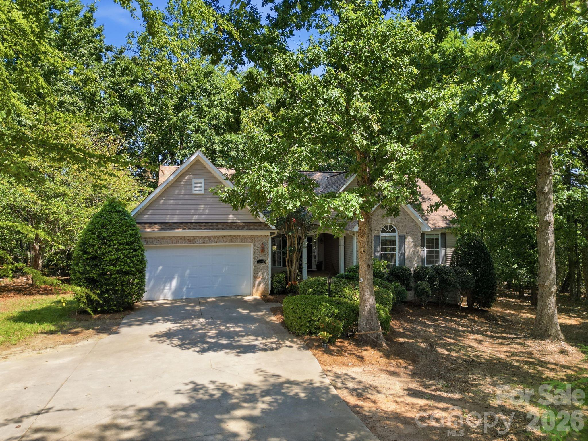 wooded lot and the front exterior elevation of the home. - 14724 Beatties Ford Road, Huntersville