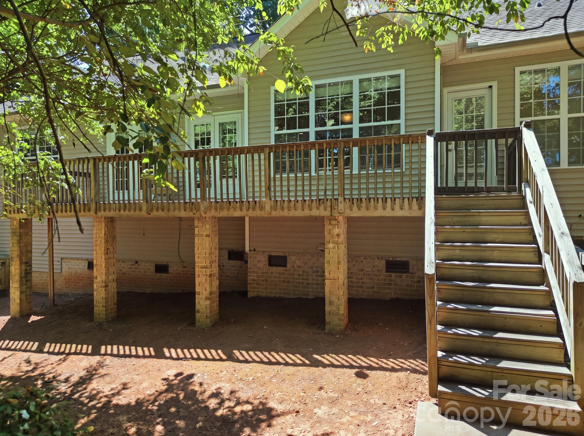 Back deck featuring stairs that provide direct access to a small, fenced-in backyard. - 14724 Beatties Ford Road, Huntersville