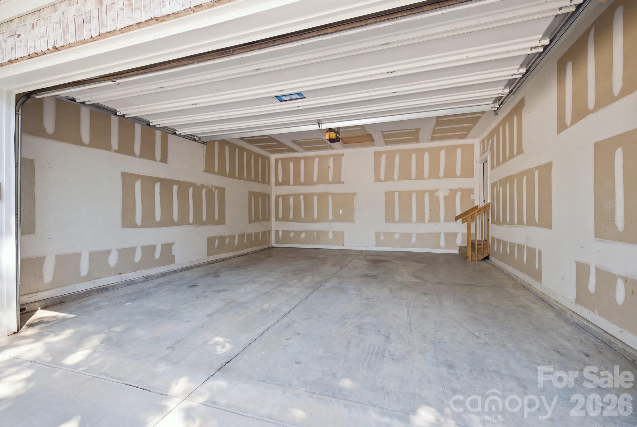 Two-car garage space. Virtually staged to take out the items in Garage - 14724 Beatties Ford Road, Huntersville