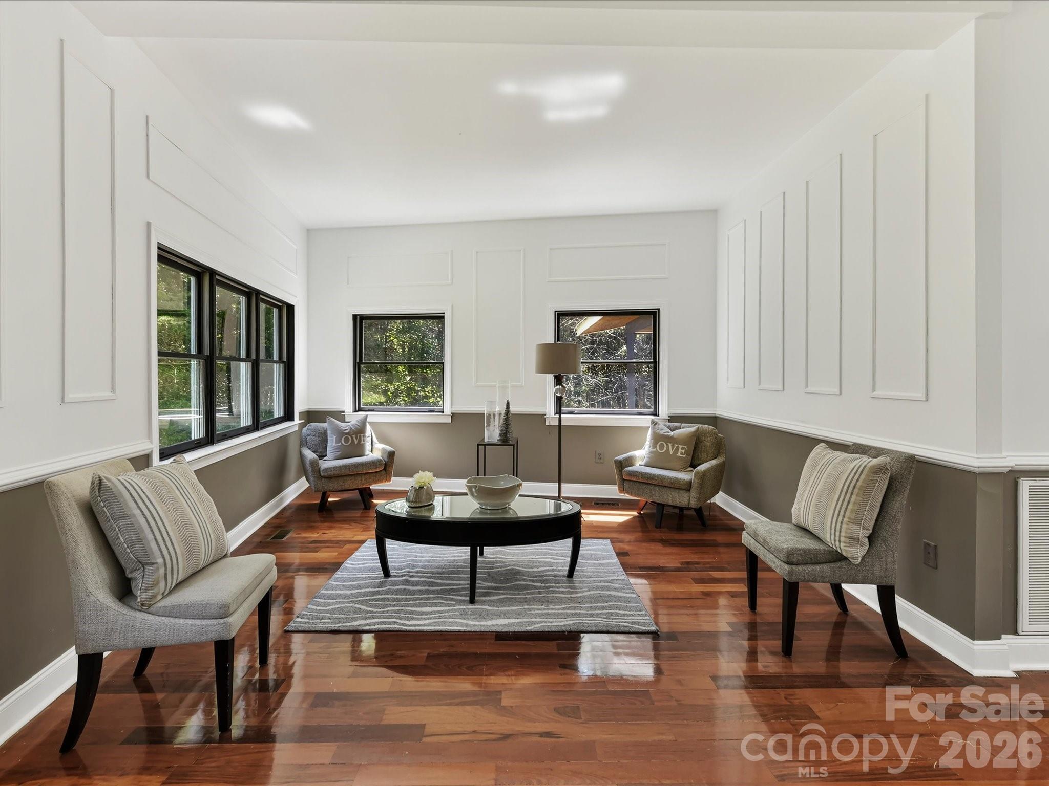Spacious living or flex space features Brazilian hardwood floors, oversized windows, abundant natural light, and peaceful wooded views. - 9821 Harvest Lane, Davidson