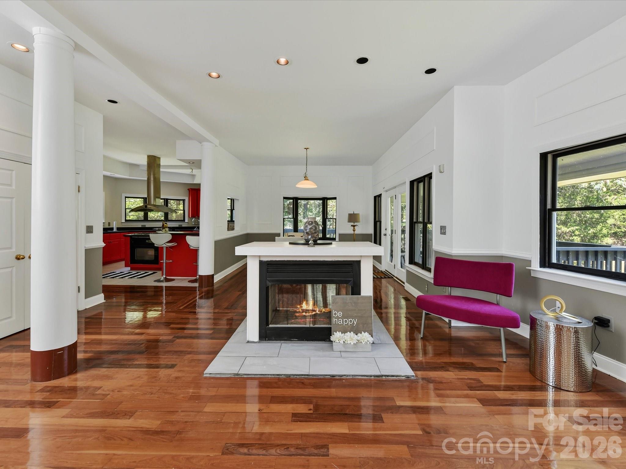 A centrally located fireplace anchors the open-concept living space, surrounded by Brazilian hardwood floors and easy flow into the kitchen and dining areas. - 9821 Harvest Lane, Davidson