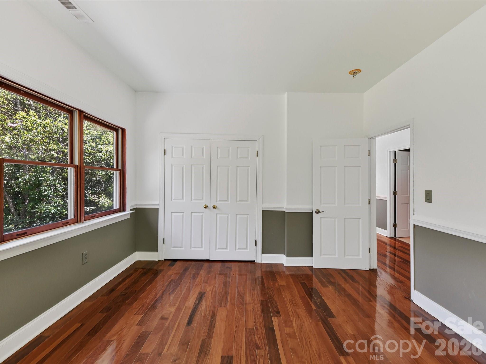 Spacious secondary bedroom offers Brazilian hardwood flooring, ample closet space, and abundant natural light. - 9821 Harvest Lane, Davidson