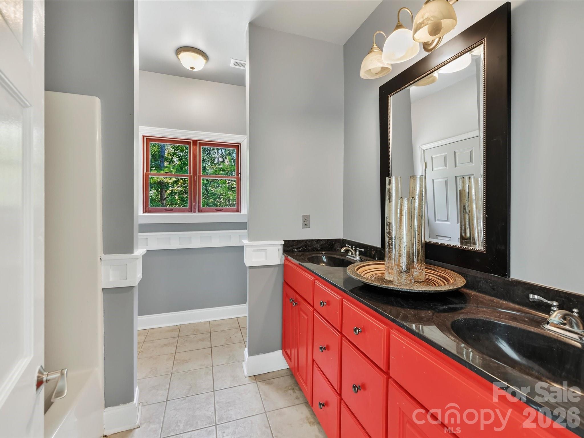 Full bath features tile flooring, generous vanity space, and classic architectural trim details. - 9821 Harvest Lane, Davidson