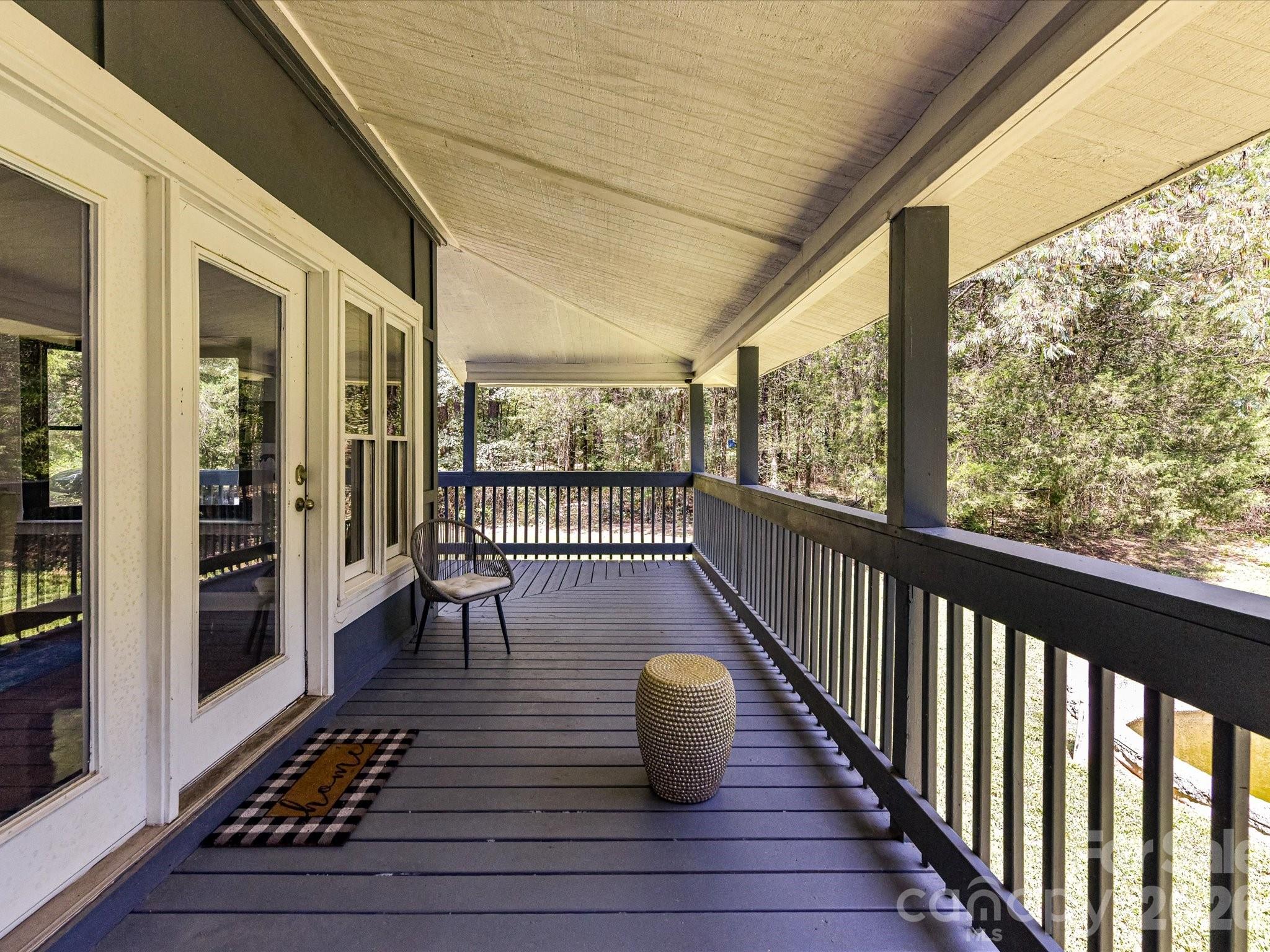 Spacious covered balcony provides a peaceful outdoor retreat overlooking the private, wooded surroundings. - 9821 Harvest Lane, Davidson