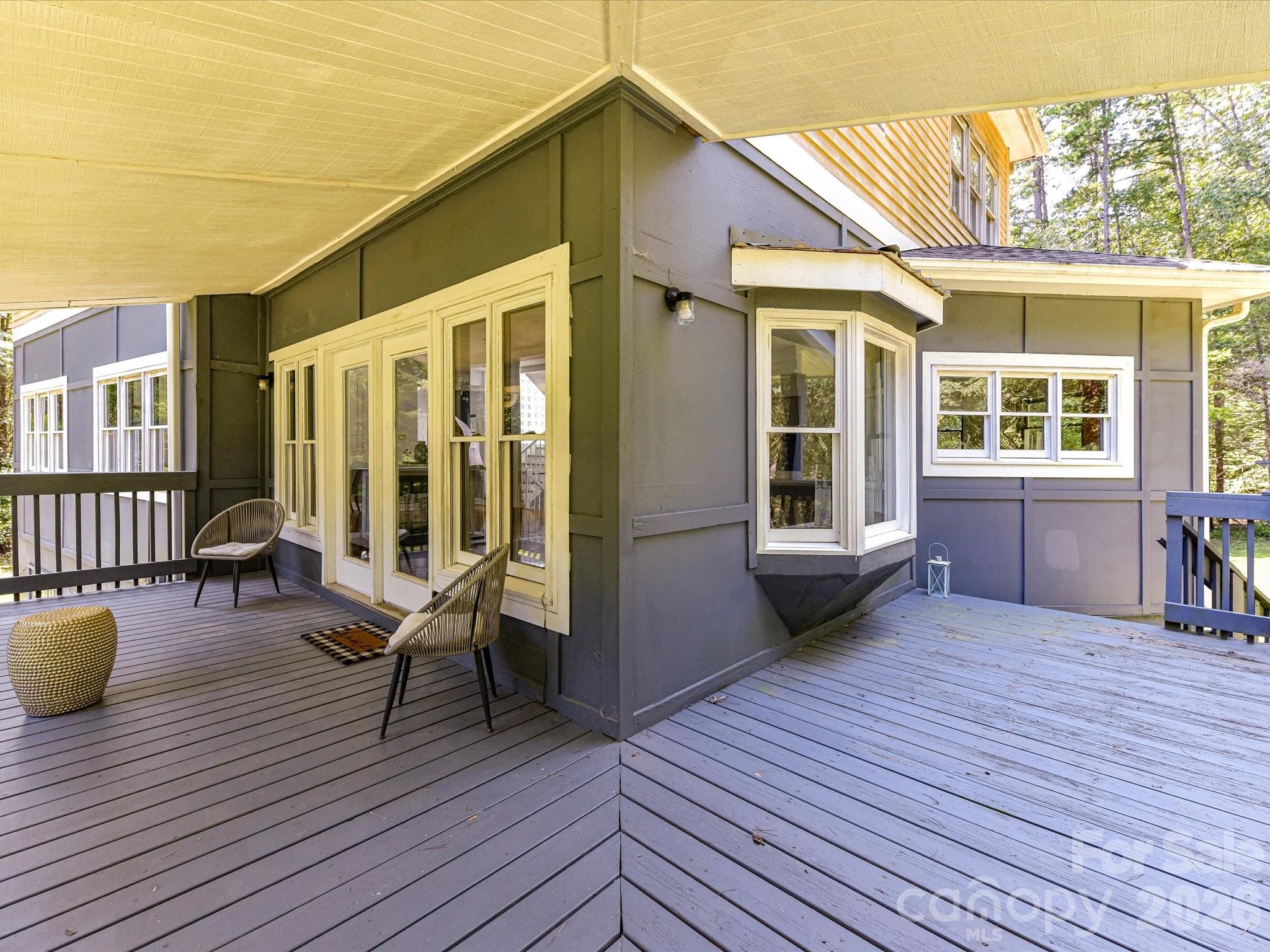 Expansive deck and covered outdoor living areas offer plenty of space for relaxing and entertaining while enjoying the surrounding natural setting. - 9821 Harvest Lane, Davidson