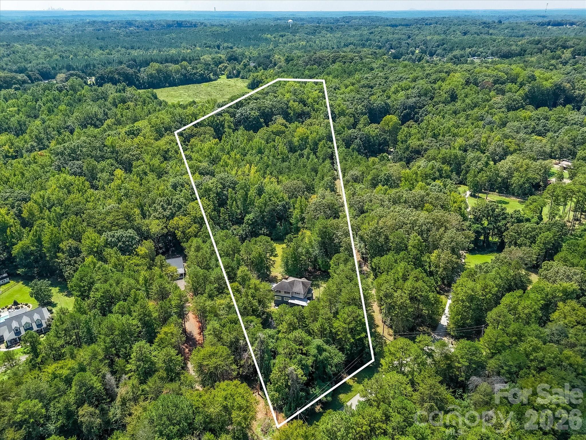 Elevated aerial view highlights the size and depth of the property, with the home tucked among mature trees and abundant green space. - 9821 Harvest Lane, Davidson