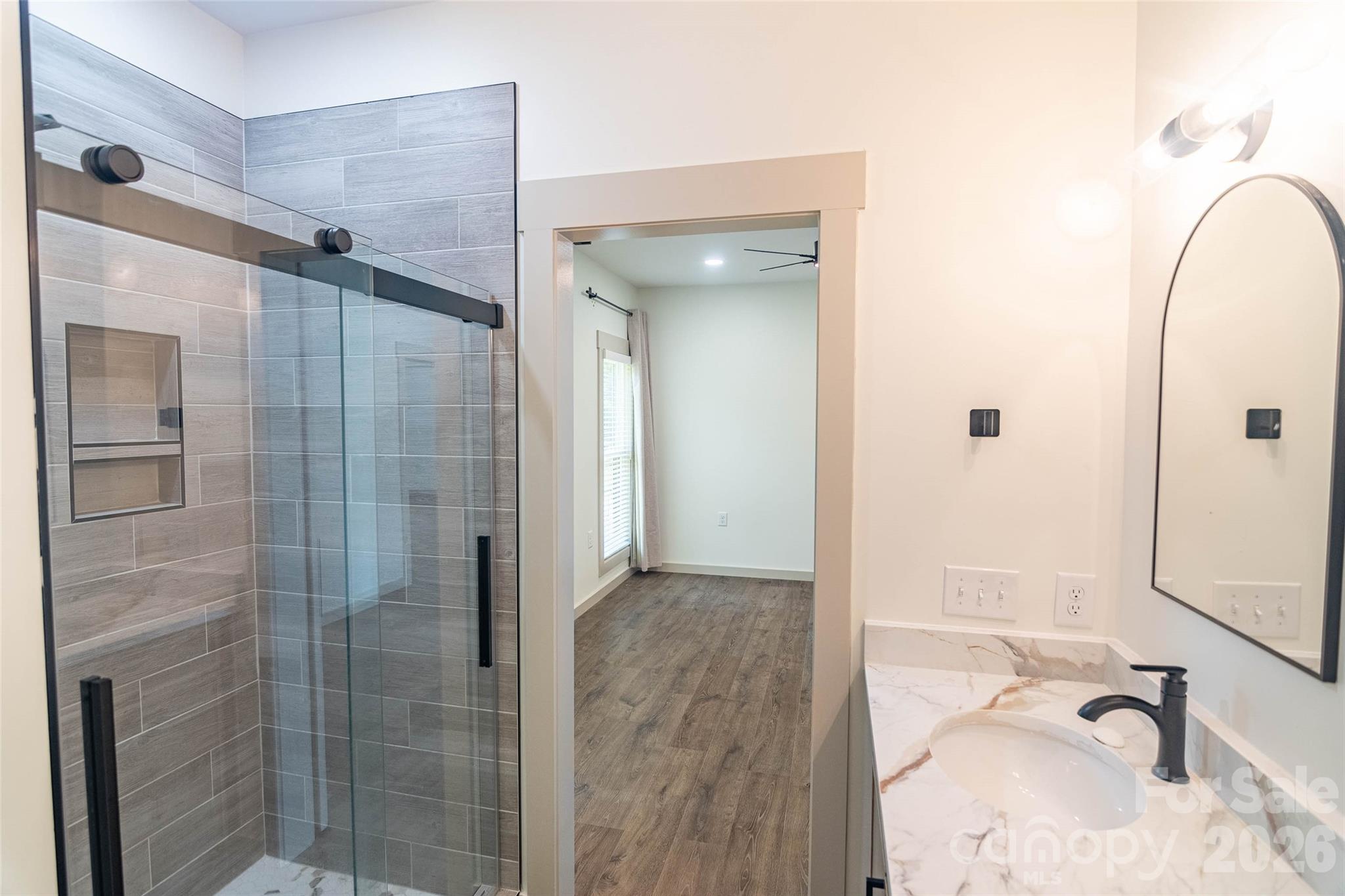 The Upgraded Glass Shower Doors in the primary bathroom is just the beginning of how cool the shower is overall.! Very stunning blend of colors and tile types.! - 98 Lexxi Lane, Tryon