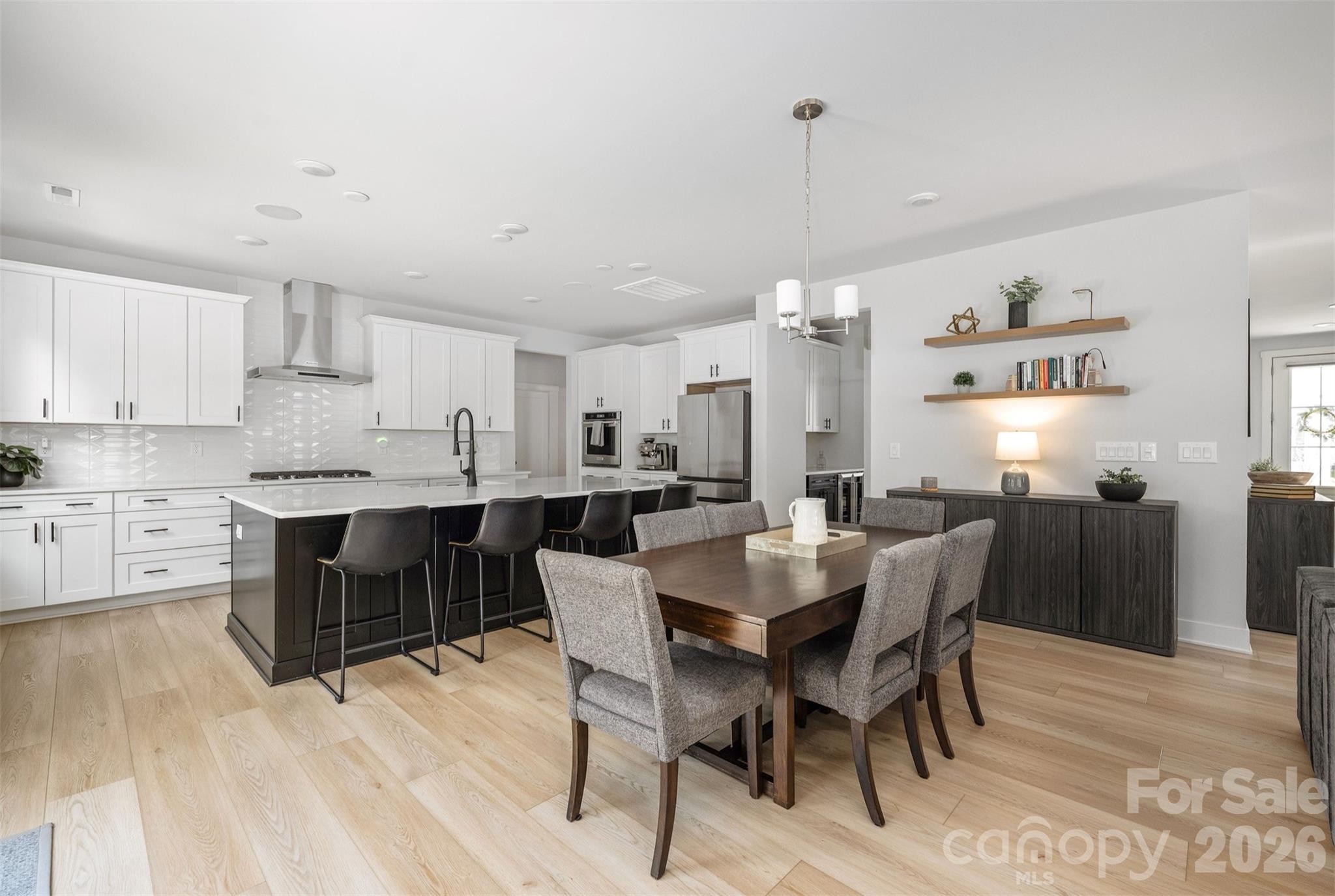Kitchen with oversized black island, quartz counters, tile backsplash to the ceiling, and KitchenAid appliances - 4320 Tournette Drive, Indian Land