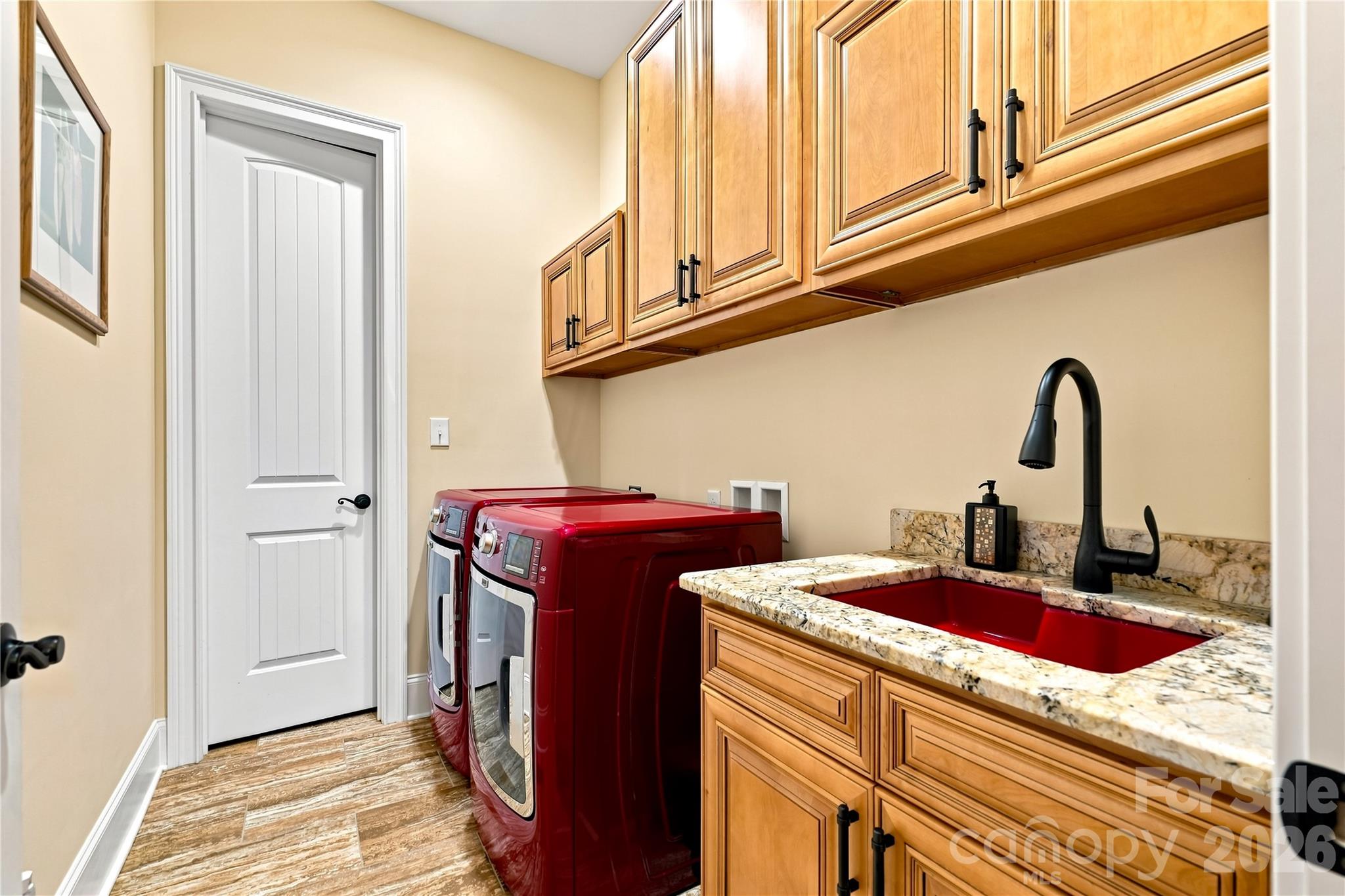 Tons of cabinet space in this main floor laundry room with utility sink - and washer/dryer to stay. AV/storage room located off laundry room too. - 108 Washam Road, Mooresville