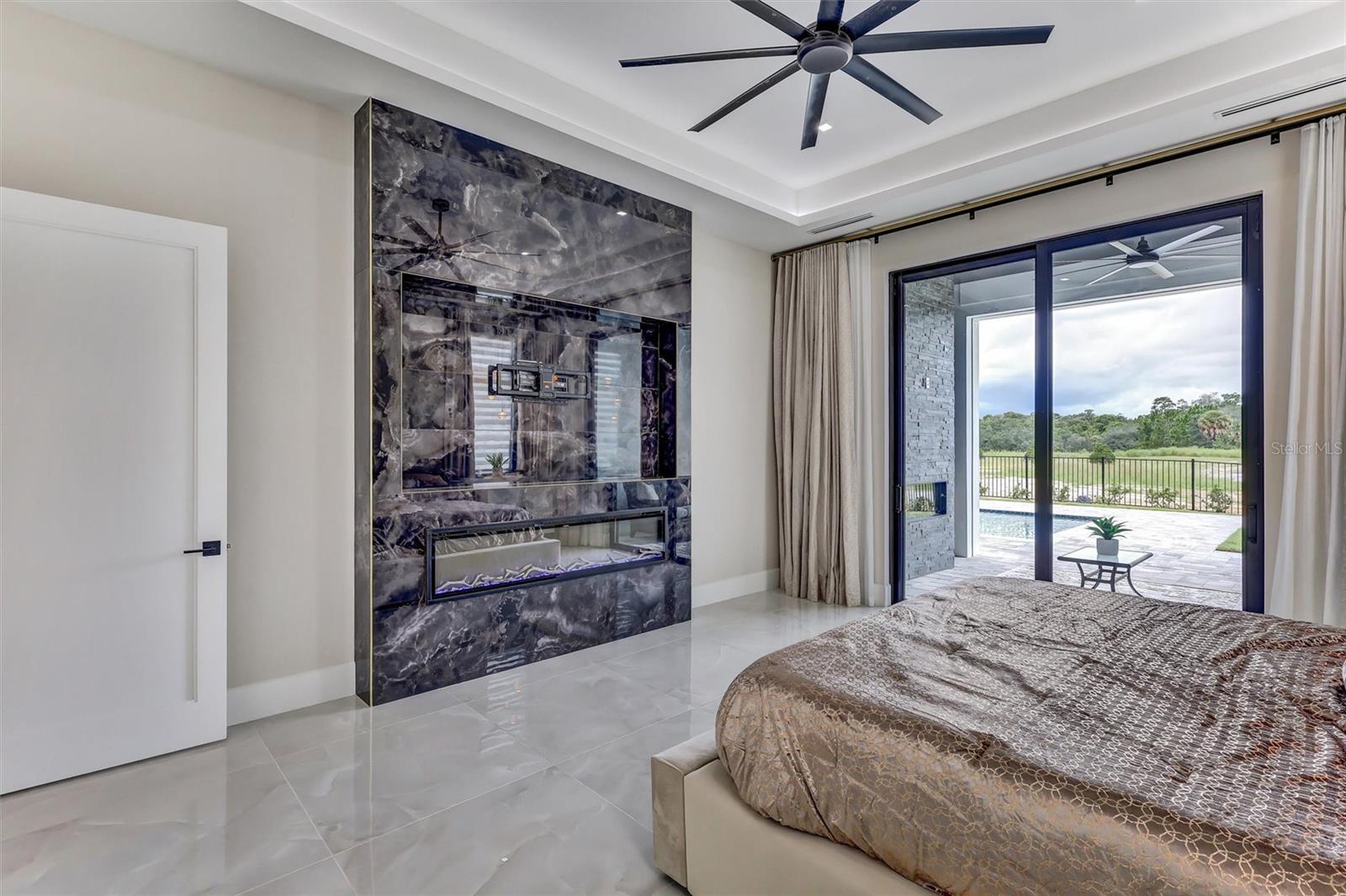 Spacious primary suite with custom feature Fireplace wall and direct outdoor access - 1002 COYOTE CREEK WAY, REUNION