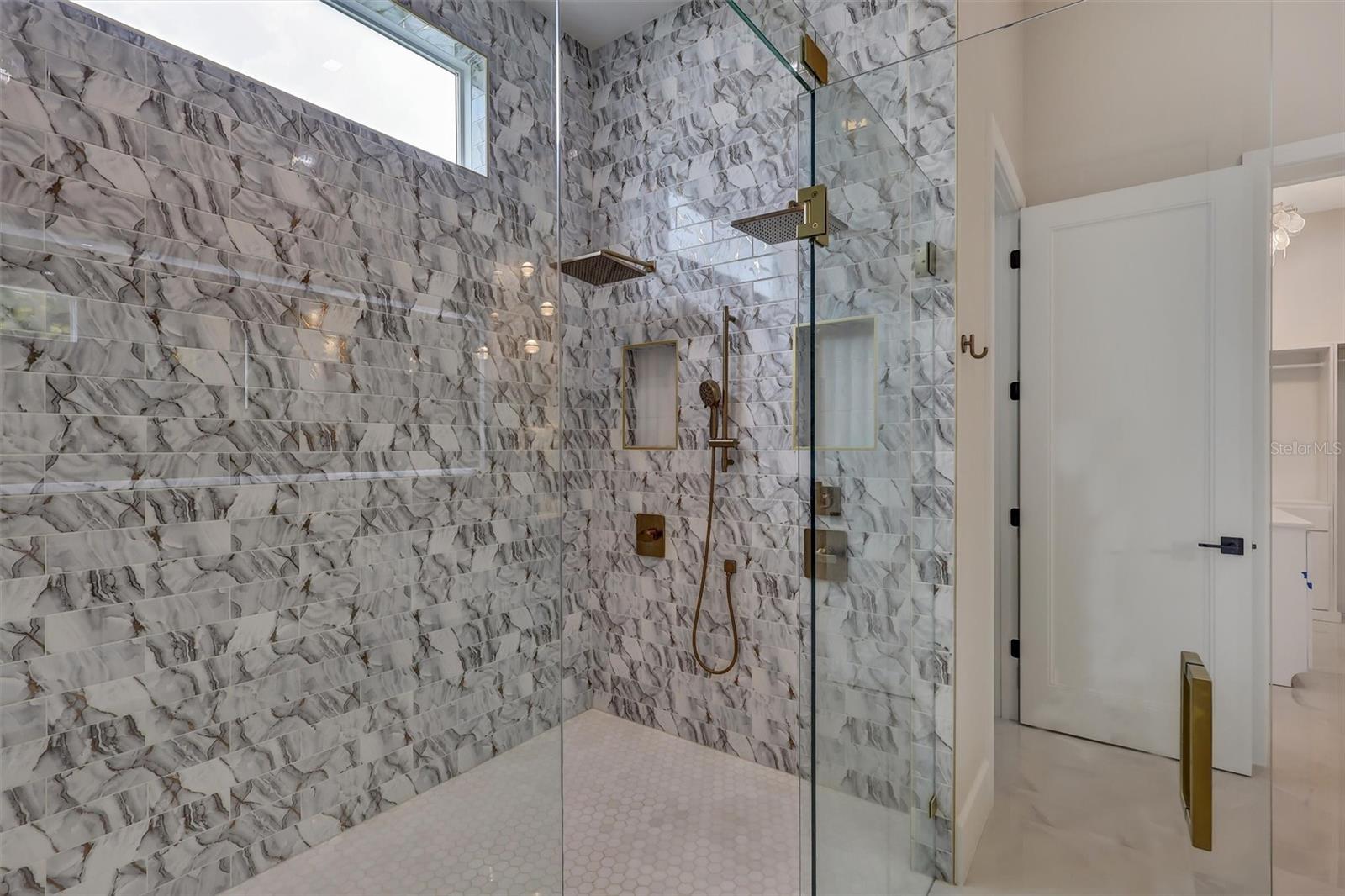 Dual-shower wet room finished in striking floor-to-ceiling stone - 1002 COYOTE CREEK WAY, REUNION