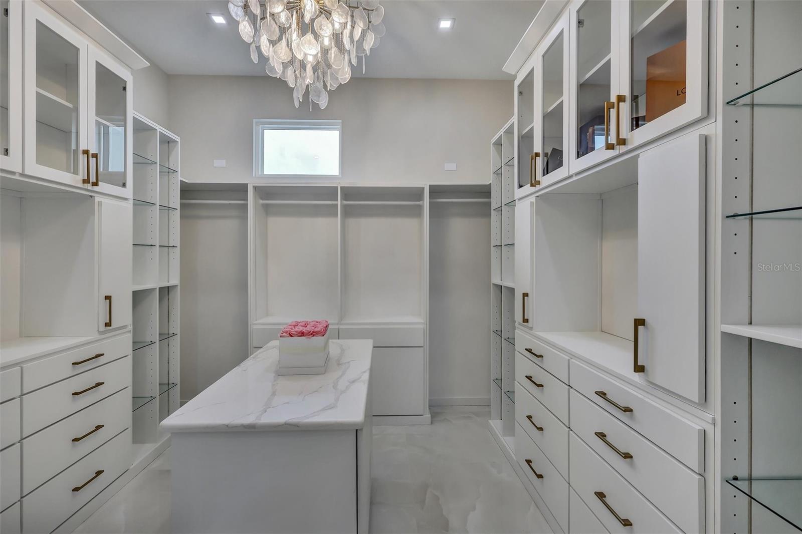 Custom primary dressing room with extensive built-in cabinetry and center island - 1002 COYOTE CREEK WAY, REUNION