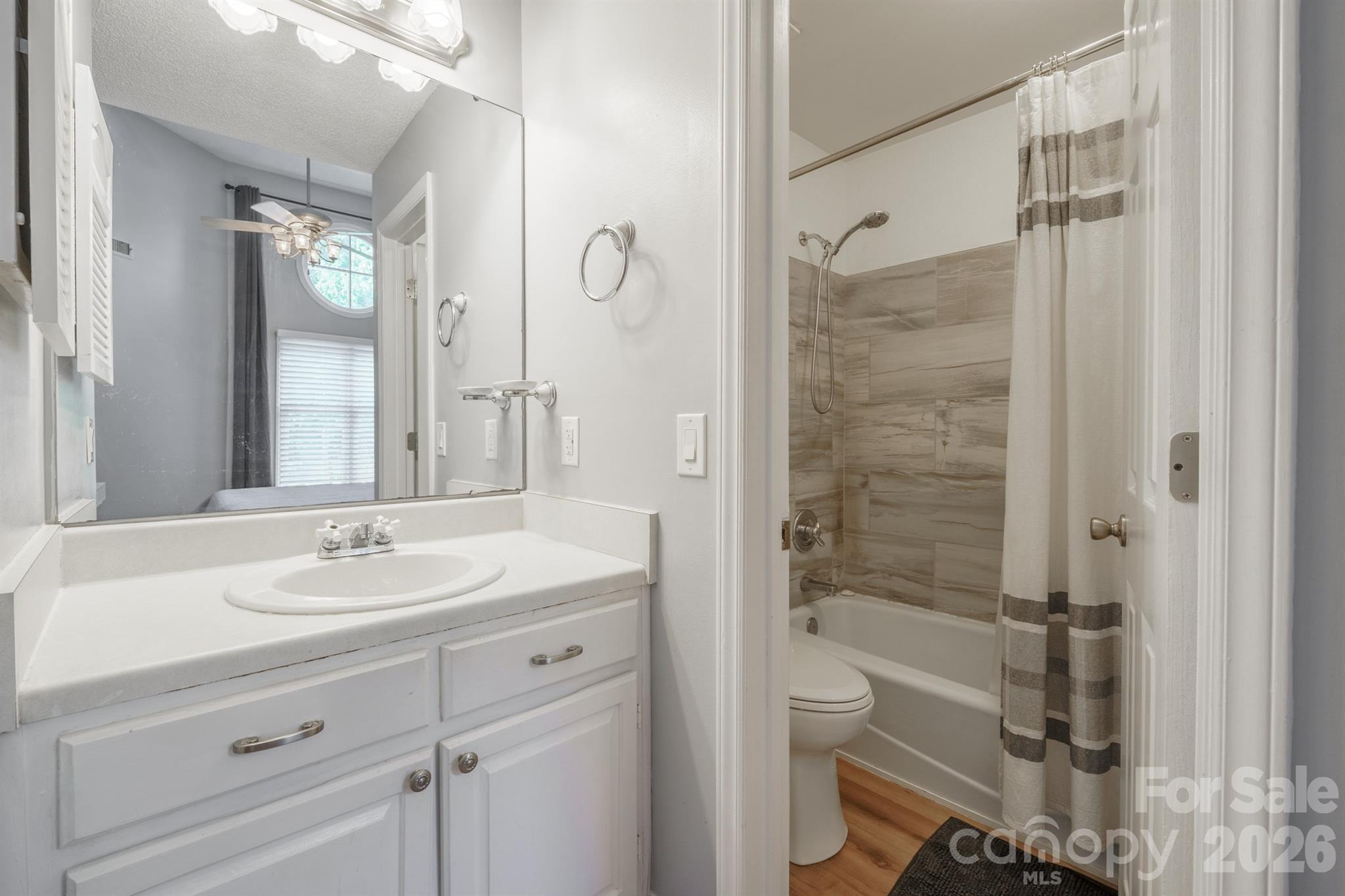 Primary bath with vanity and updated tiled shower tub combo - 327 Northwest Drive, Davidson