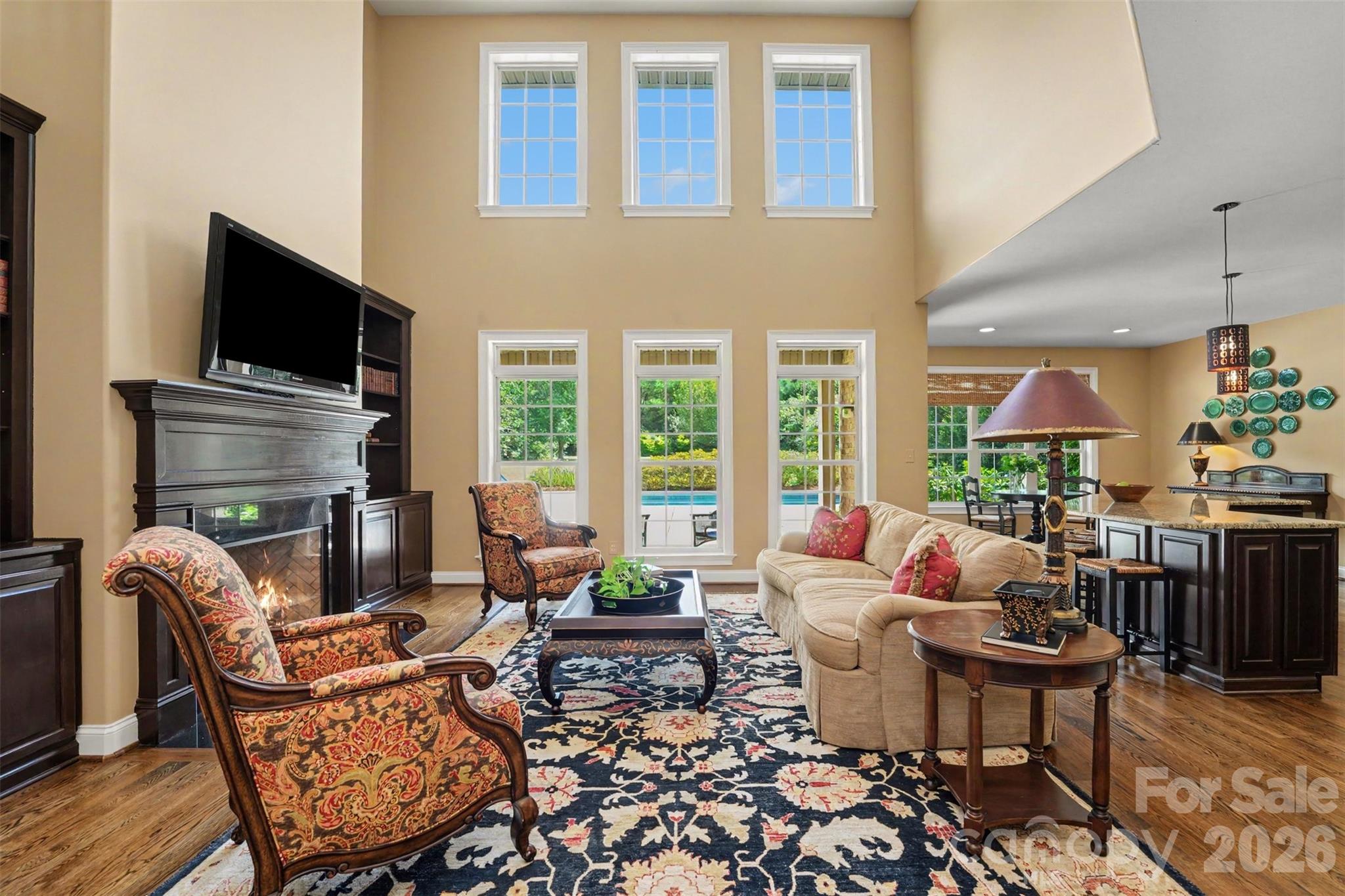 Great room overlooks the pool in and is open to the kitchen and breakfast nook. Extra large windows provide natural sunlight. - 120 Palos Verde Drive, Mooresville