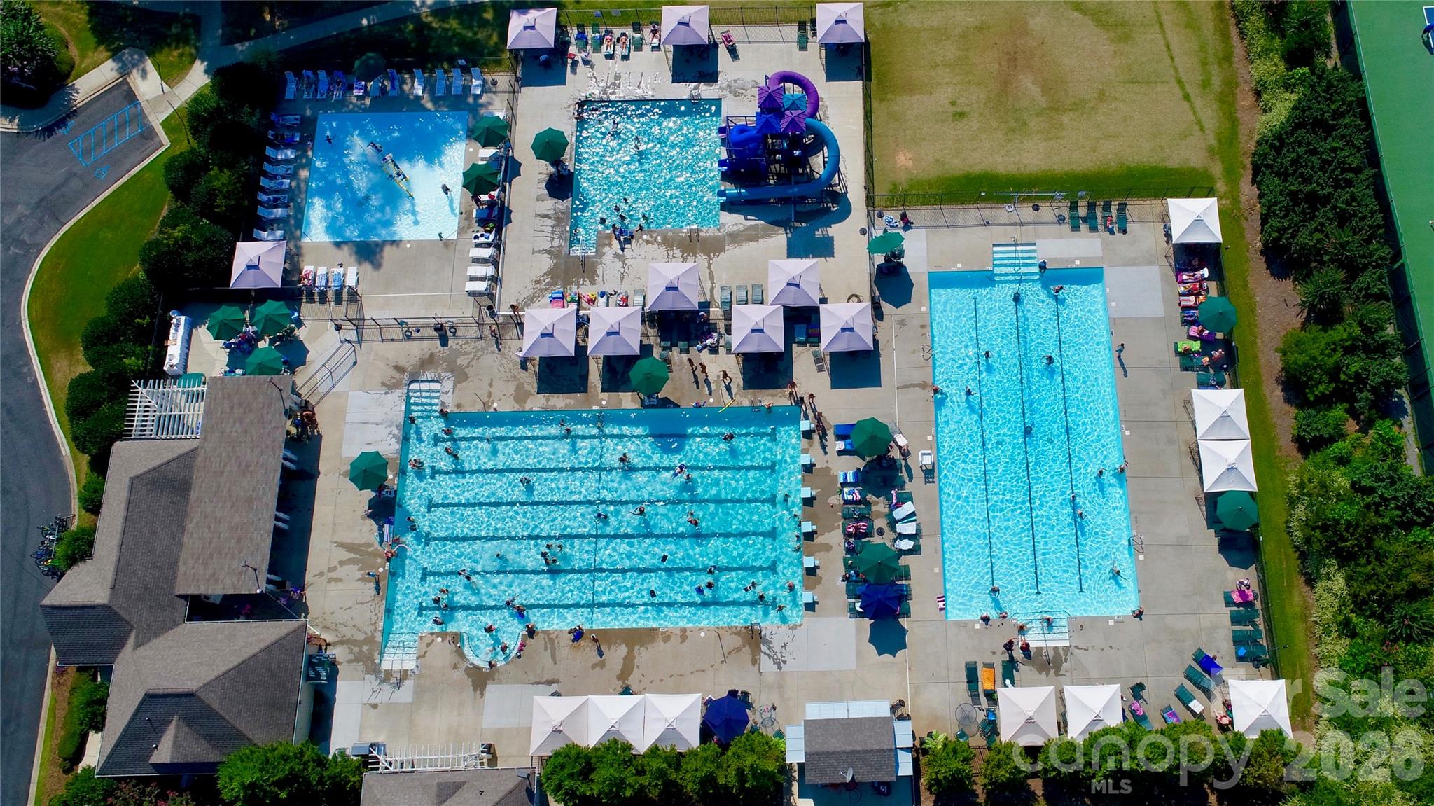Aerial view of the 4 swimming pools which include a main pool, kiddie gadget pool, a pool with 3 slides, and an adults only pool - pool area also includes a Tiki Bar. - 12822 Cadgwith Cove Drive, Huntersville