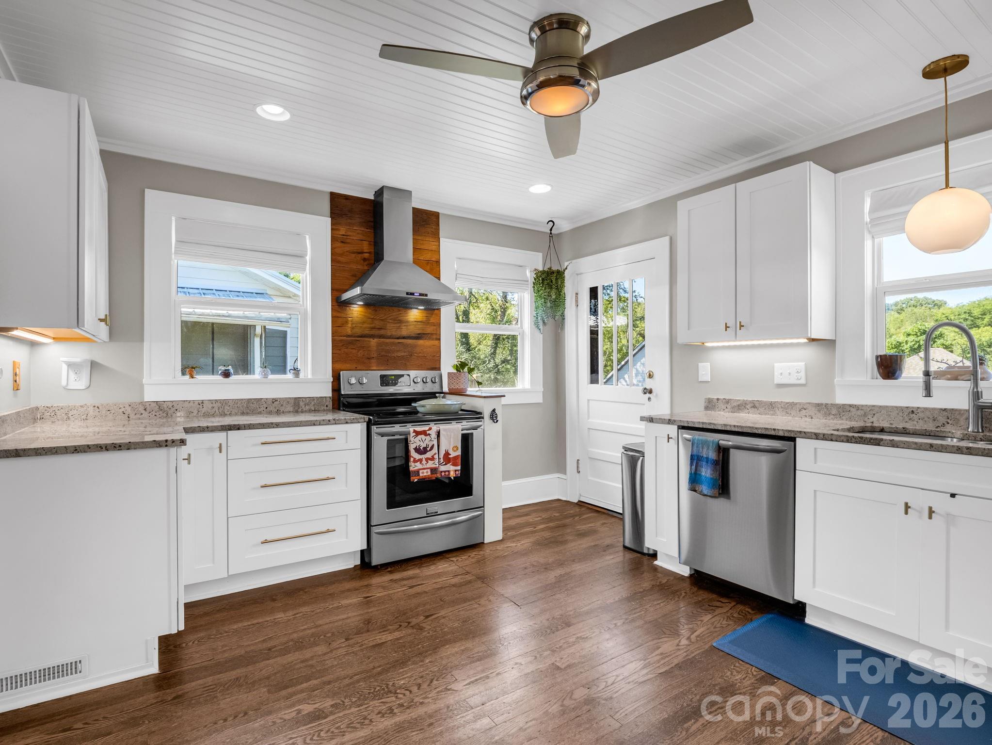 fantastic modern kitchen with stone counters, range hood, upgraded appliances & cabinets and floating shelves - 10 Dale Street, Asheville