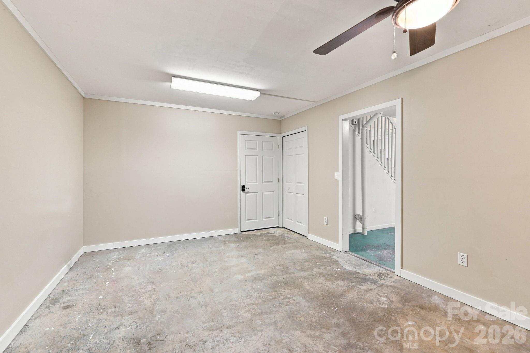 Partially finished room with ceiling fan in basement. - 95 Holly Ridge Road, Waynesville