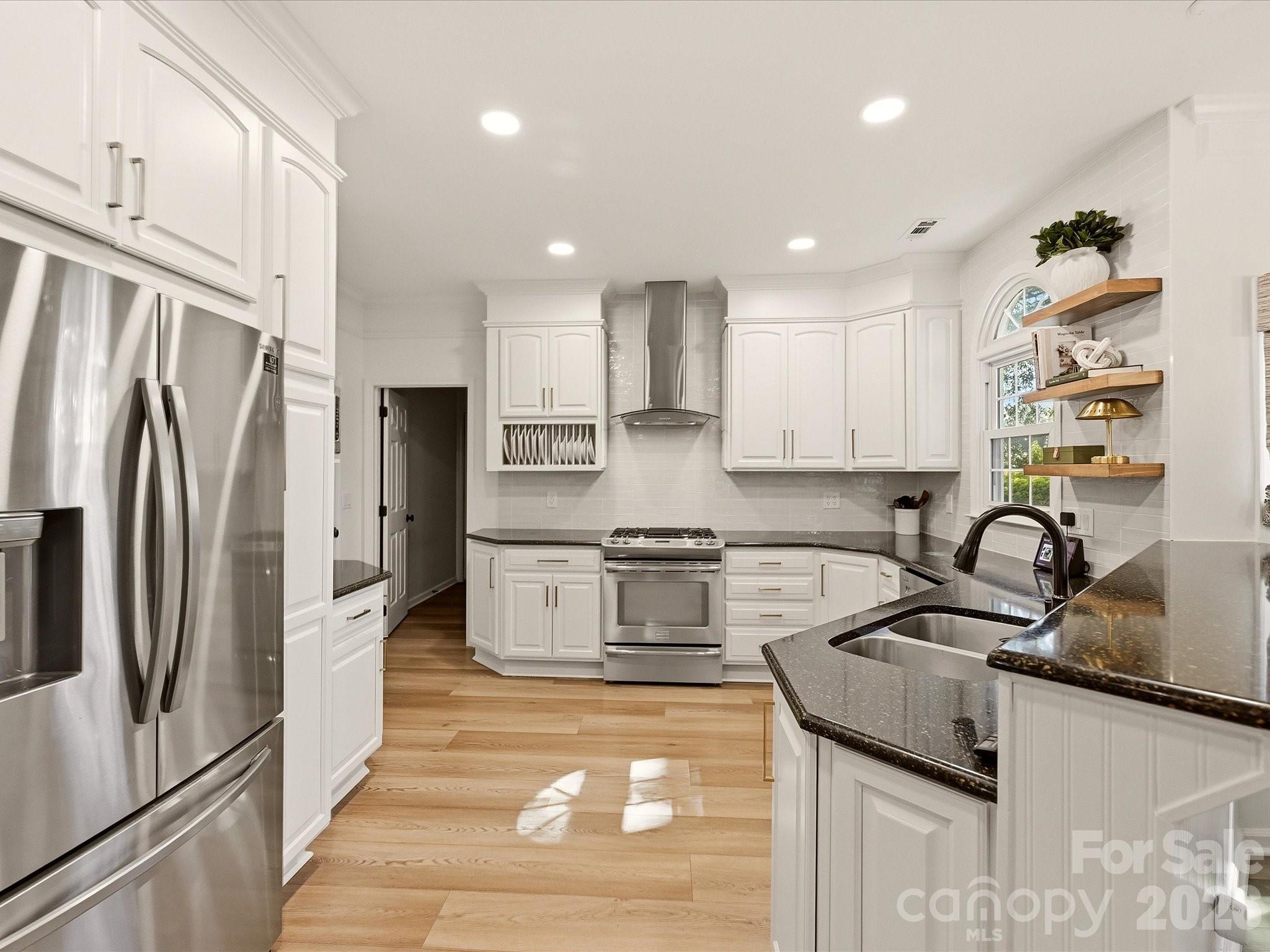 Bright updated kitchen offers extensive counter space, stainless steel appliances, recessed lighting, and plenty of cabinetry for storage. - 19706 Valiant Way, Cornelius