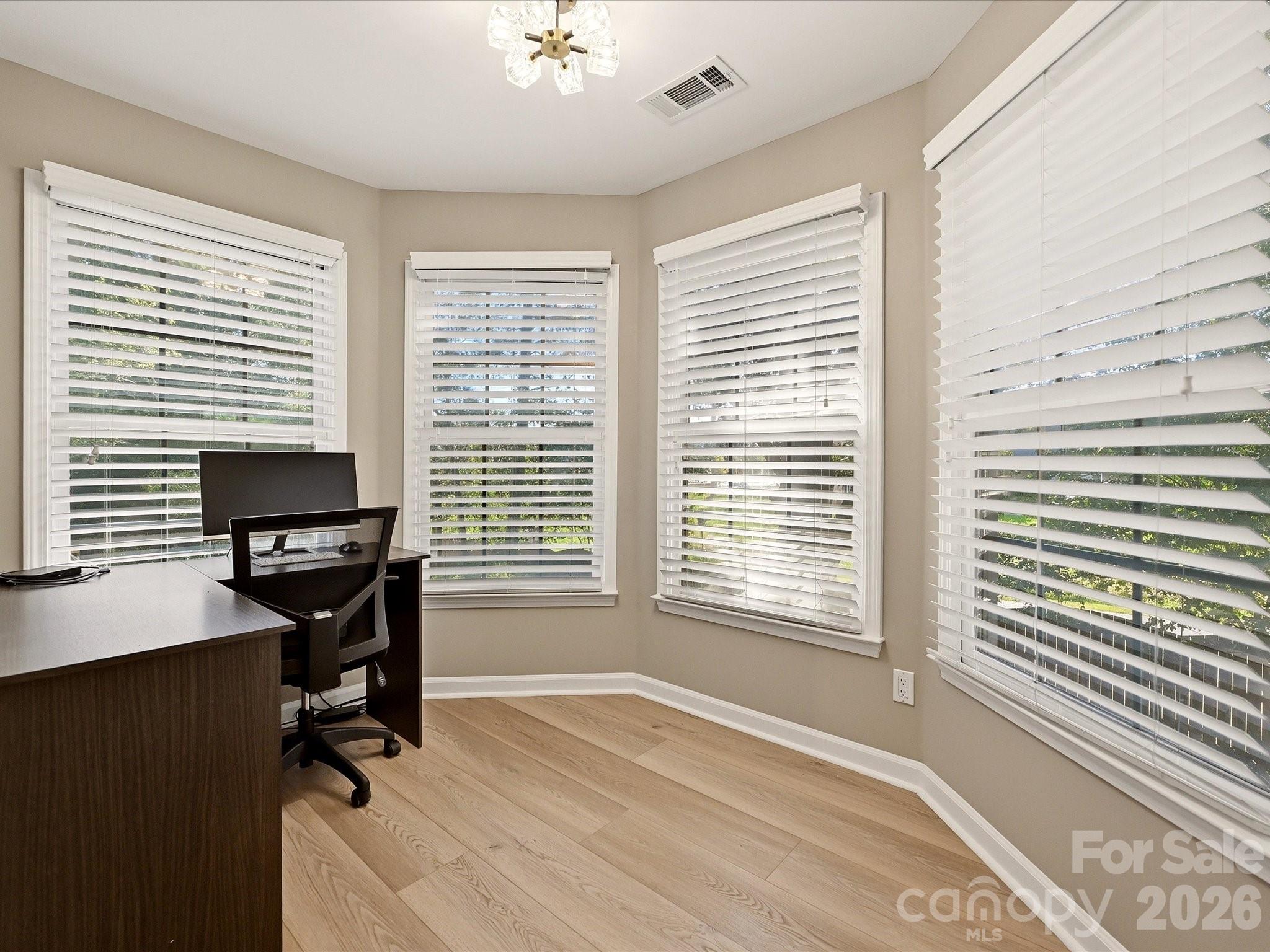 Private sitting area in the primary suite is surrounded by windows and offers flexible space for an office, reading nook, or lounge. - 19706 Valiant Way, Cornelius