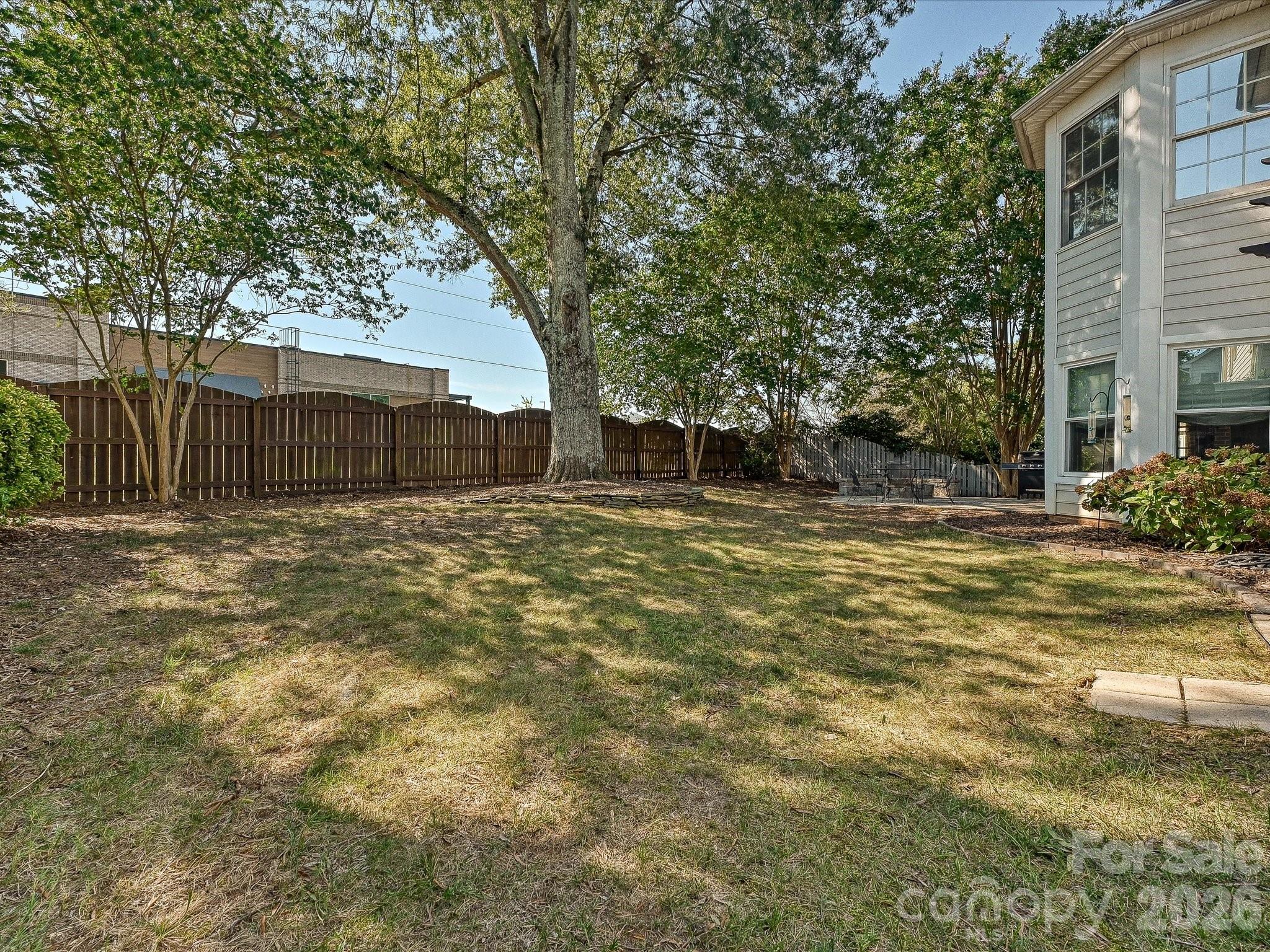 Level fenced backyard offers lawn space, mature shade trees, and plenty of room for outdoor recreation. - 19706 Valiant Way, Cornelius