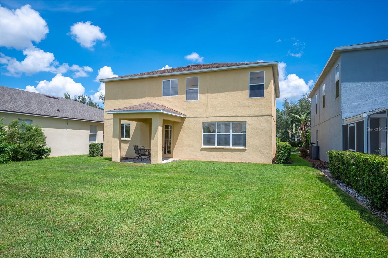A rear view of the home and its covered rear patio , perfect for enjoying morning coffee or evening sunsets - 6937 LAKE EAGLEBROOKE DR, LAKELAND