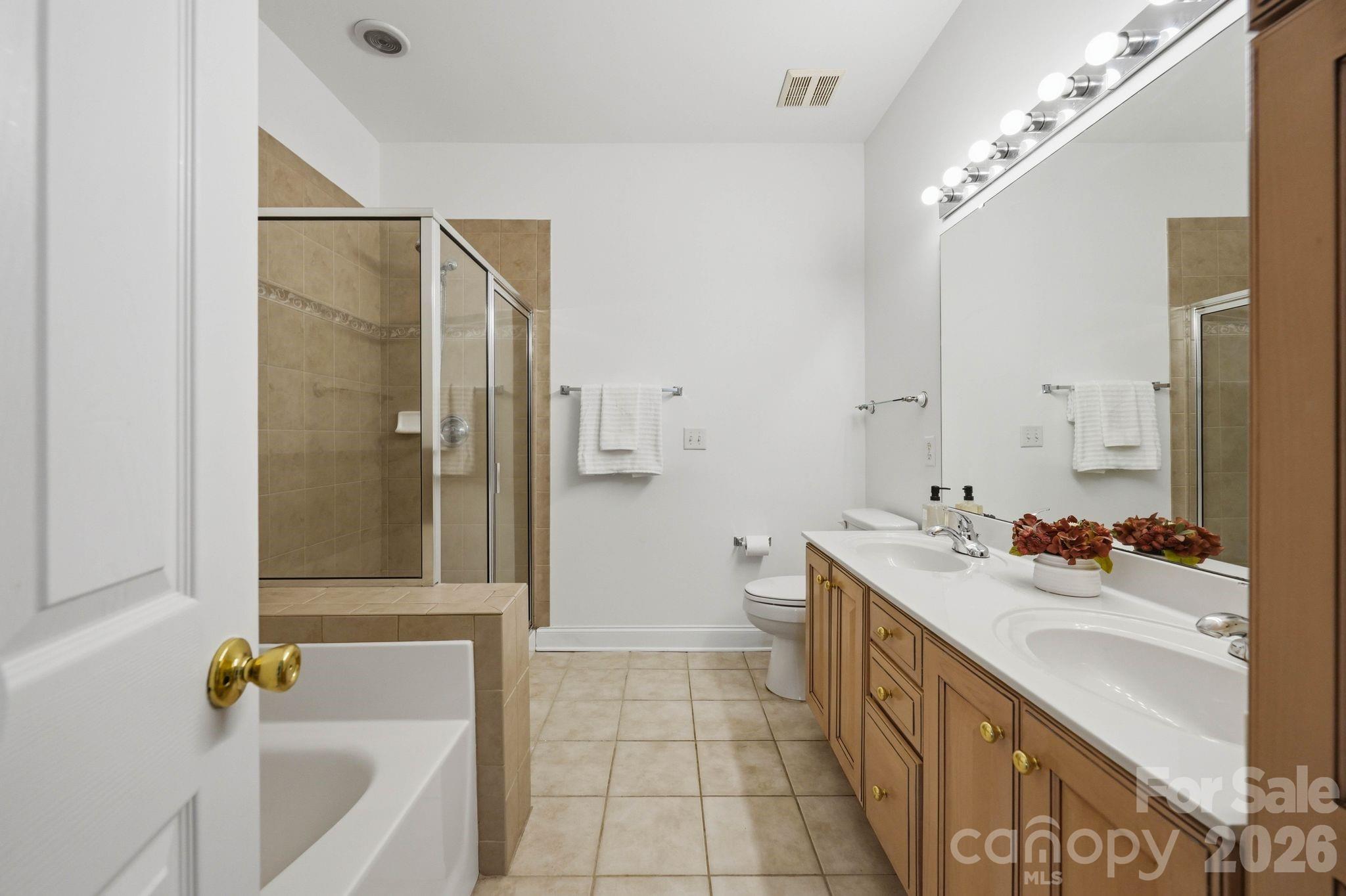 Main-level primary bath offers generous counter space and dual-sink vanity. - 18810 Cloverstone Circle, Cornelius