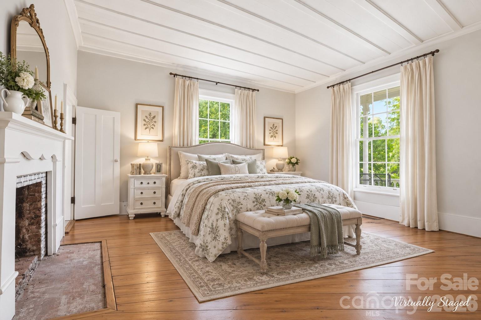 Main floor primary just off the central hallway, also with a fireplace (see disclosures), a walk-in closet and linen closet and board-and-batten ceilings. - 10915 Beatties Ford Road, Huntersville