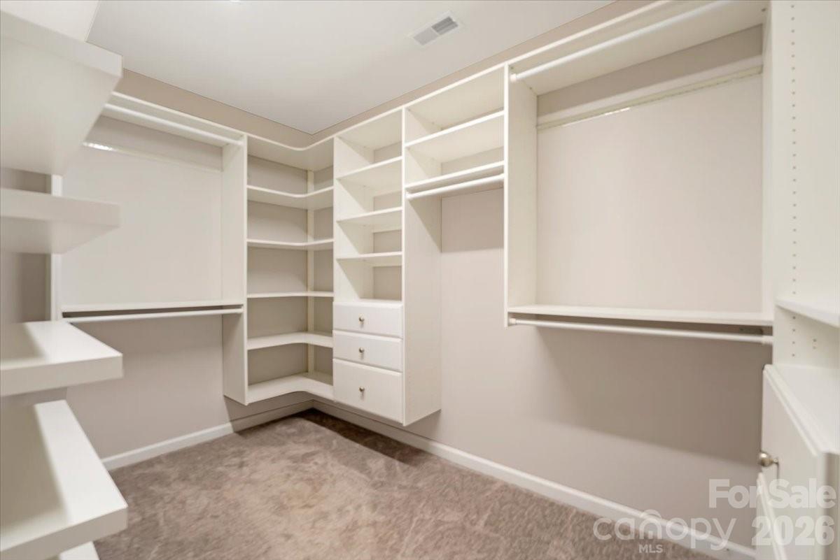 Spacious primary closet with a custom built in organization system. - 144 Steeplechase Avenue, Mooresville