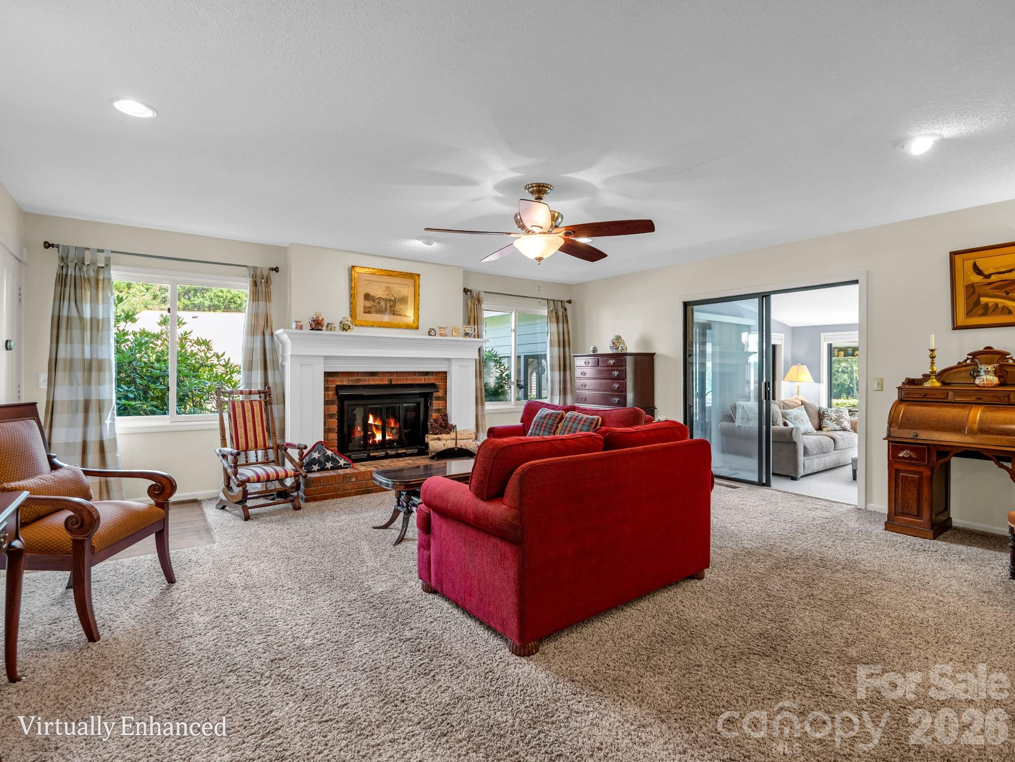 Living room with propane gas fireplace, sliding doors to 4 seasons sunroom, abundant natural light, new fireplace surround - 31 Willow Way, Hendersonville