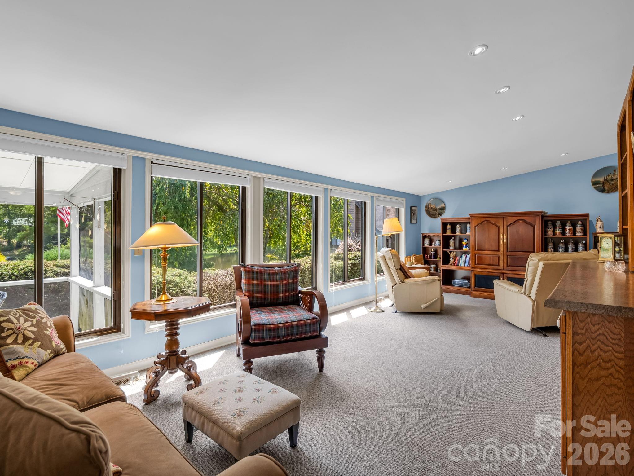 An abundance of natural light fills the four seasons sunroom overlooking the lake - 31 Willow Way, Hendersonville