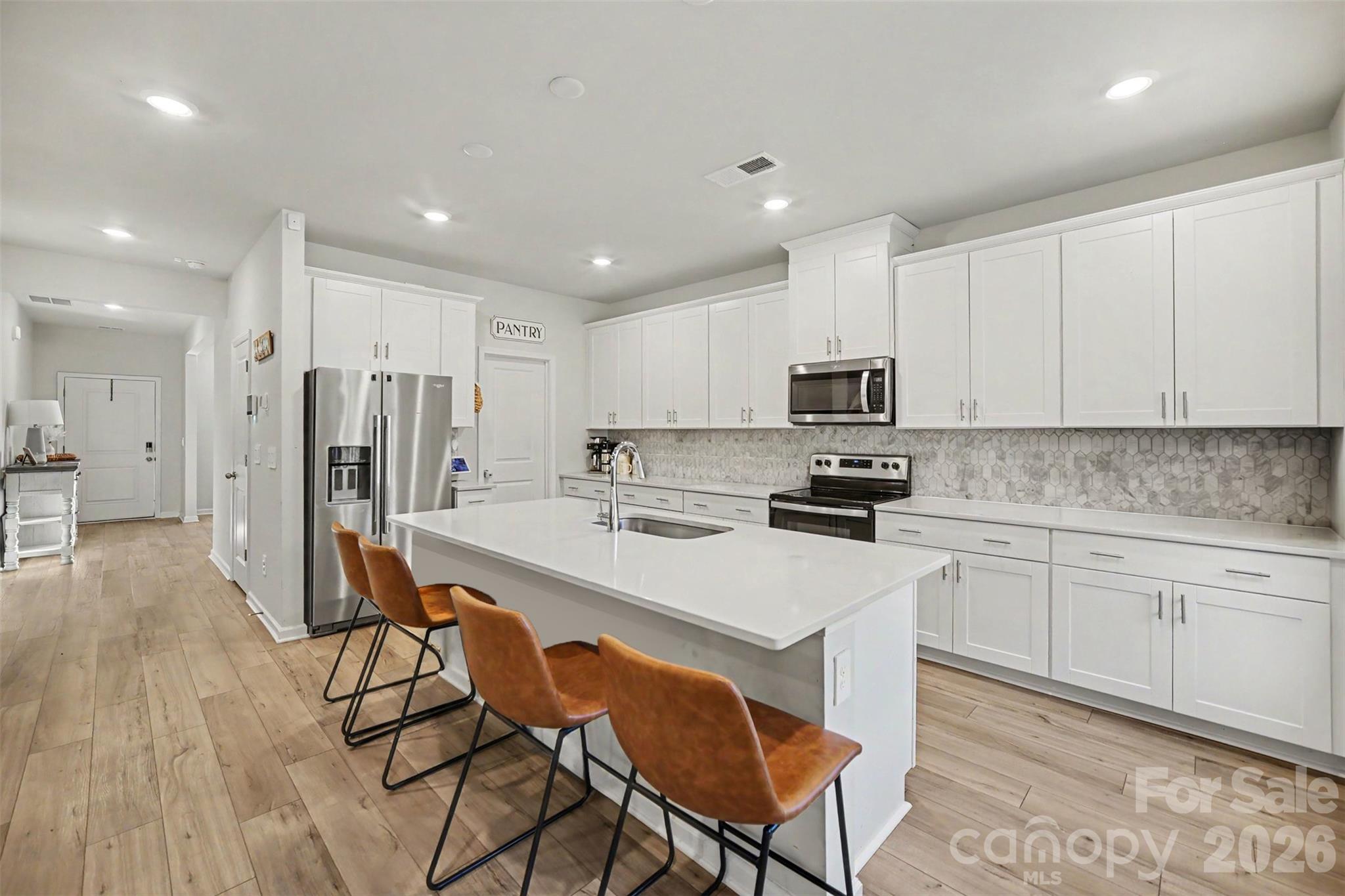 A stylish kitchen with crisp white cabinetry. - 1623 Baymont Court, Stanley