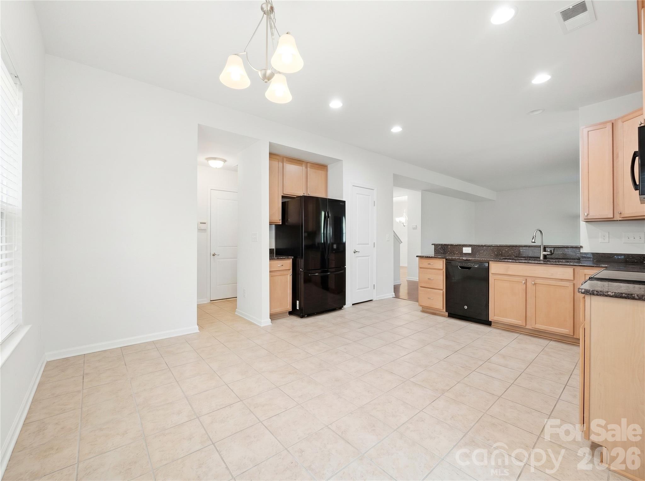 Kitchen: Open kitchen with generous cabinet storage, black appliances, and easy flow to the living and dining areas. - 3341 Linetender Drive, Davidson