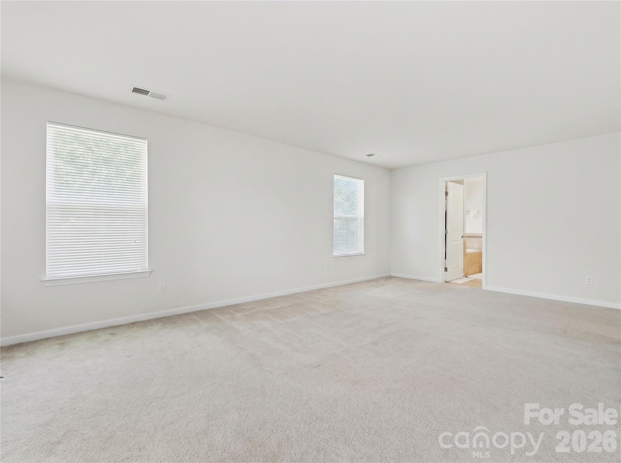 Primary Bedroom: Primary bedroom with direct access to the ensuite bath and secondary walk-in closet. - 3341 Linetender Drive, Davidson