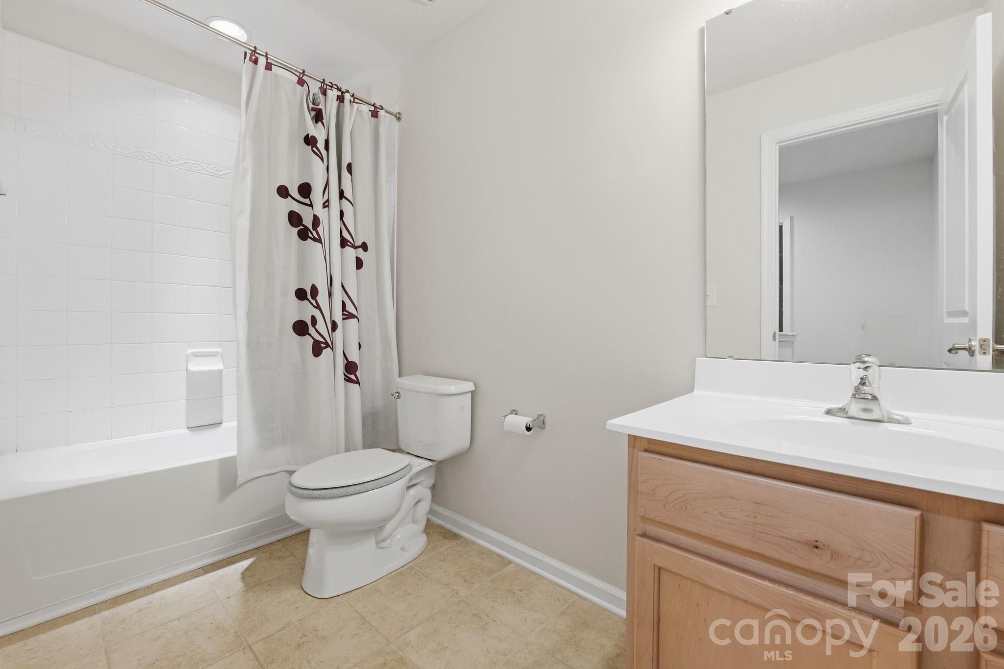 Guest Bathroom: Full bathroom featuring a maple vanity, tile flooring, and tub/shower combination. - 3341 Linetender Drive, Davidson