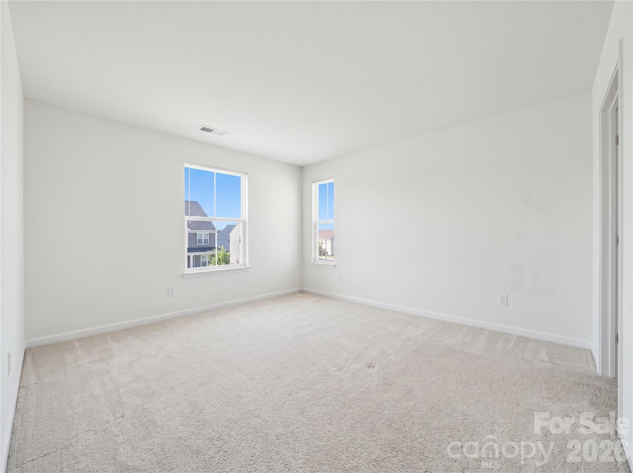 Bedroom 2: Secondary bedroom with neutral finishes, plush carpeting, and ample natural light. - 3341 Linetender Drive, Davidson