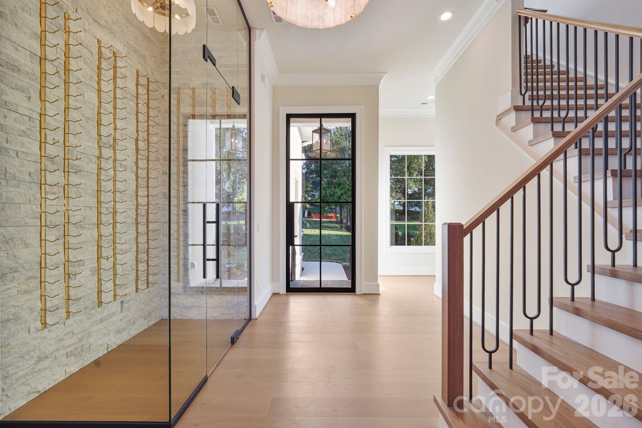 Grand foyer featuring a dramatic 10' steel front door and custom wine display, creating a striking first impression upon entry. - 21216 Rio Oro Drive, Cornelius