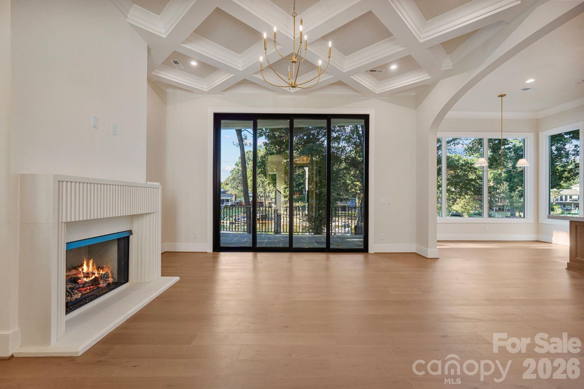 Family room featuring soaring 12' ceilings and a custom diamond-coffered ceiling that adds architectural detail and character. - 21216 Rio Oro Drive, Cornelius