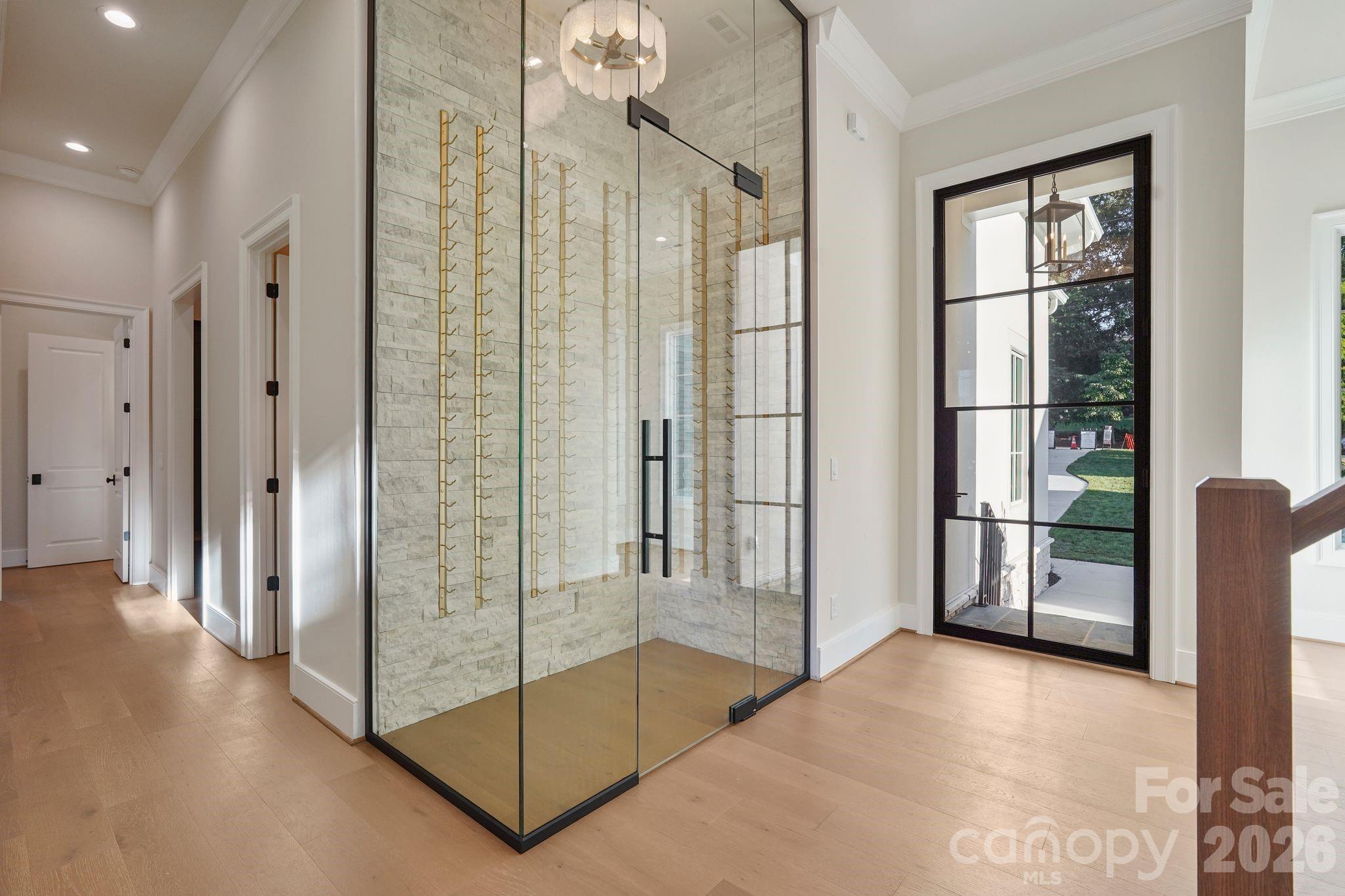 Elegant foyer featuring 7" white oak flooring and a thoughtfully concealed powder room, providing added privacy while maintaining a clean, sophisticated entry. - 21216 Rio Oro Drive, Cornelius