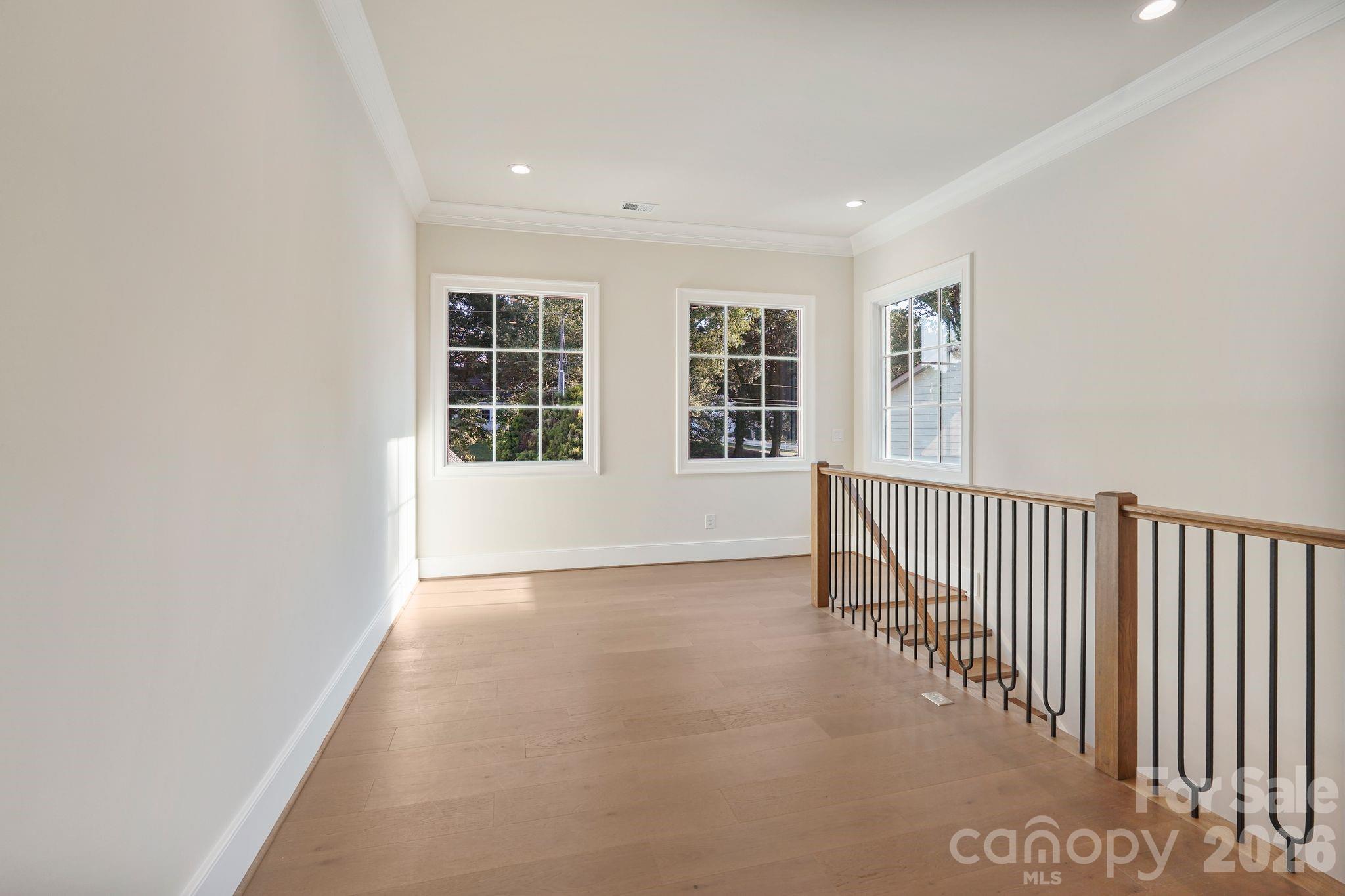 Upstairs gallery filled with natural light from expansive windows, creating an open, airy transition while capturing beautiful main-channel water views. - 21216 Rio Oro Drive, Cornelius