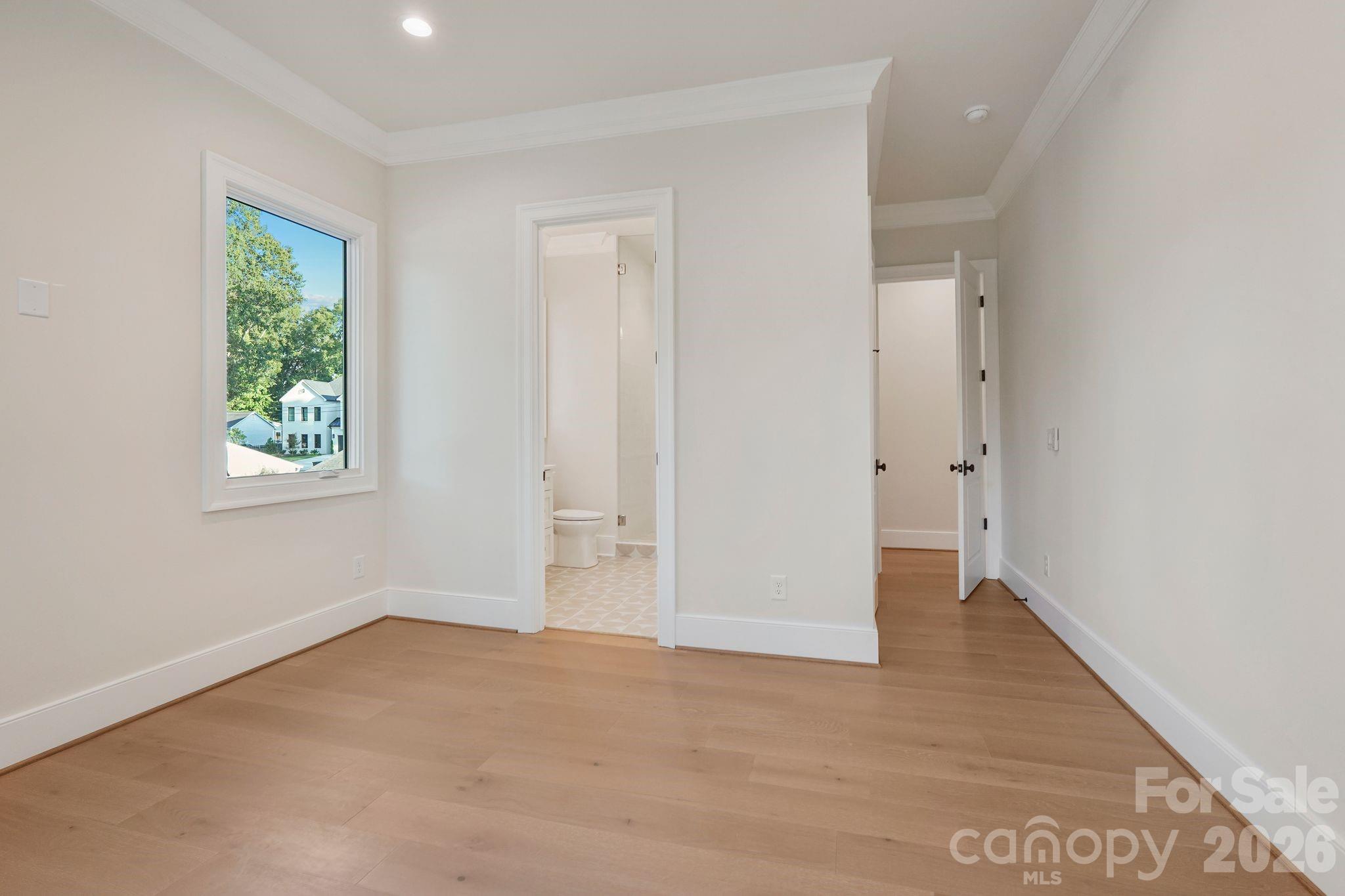 Bedroom 3 is filled with natural light from expansive windows and features a spacious walk-in closet, combining comfort with generous storage. - 21216 Rio Oro Drive, Cornelius
